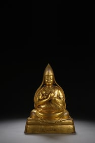 A BRONZE-GILT SEATED LAMA