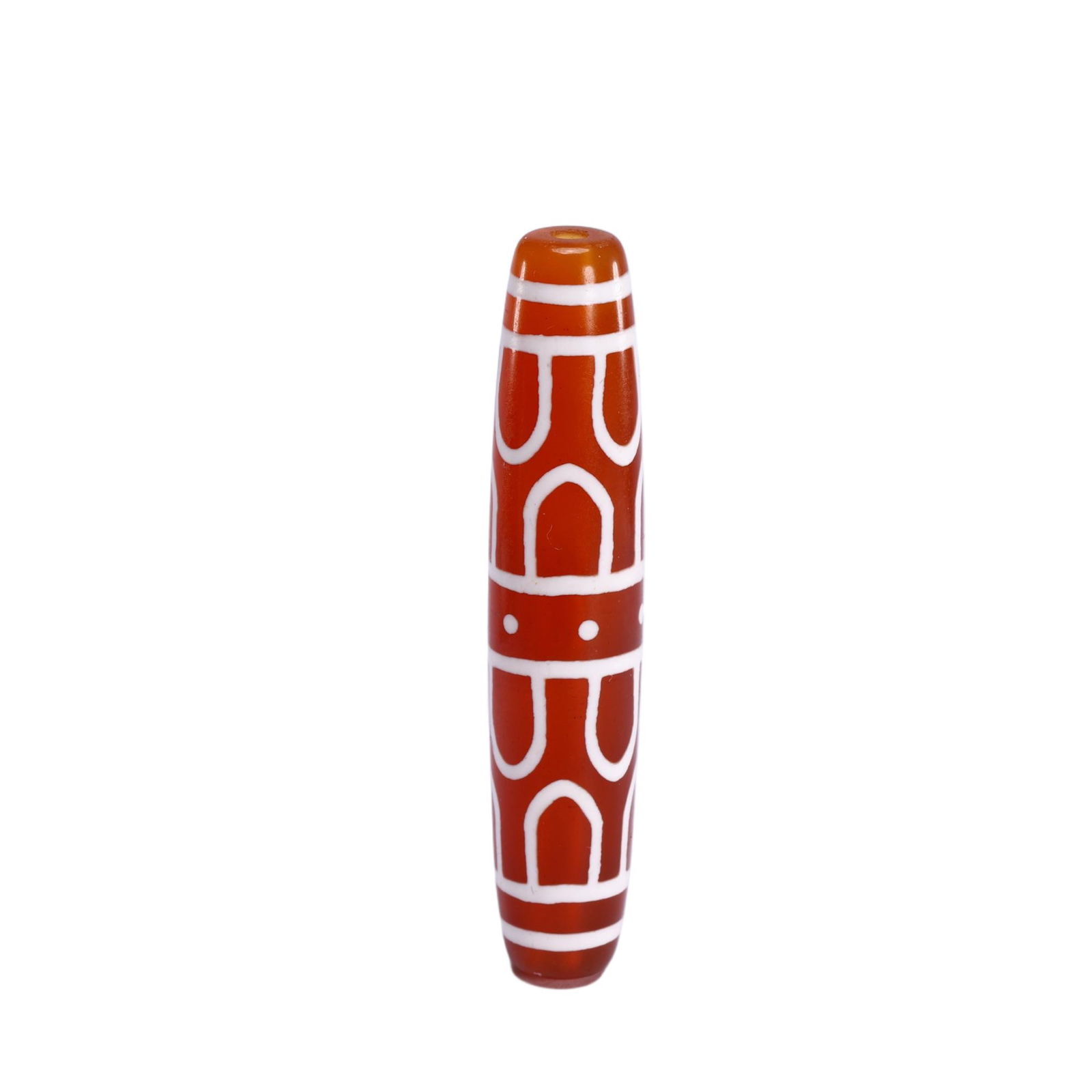 A TIBETAN DZI BEAD: A TIBETAN DZI BEAD This elongated Chinese carnelian dzi bead is adorned with striking white inlaid patterns. The design features repeating arched motifs, horizontal bands, and two circular dots, creat