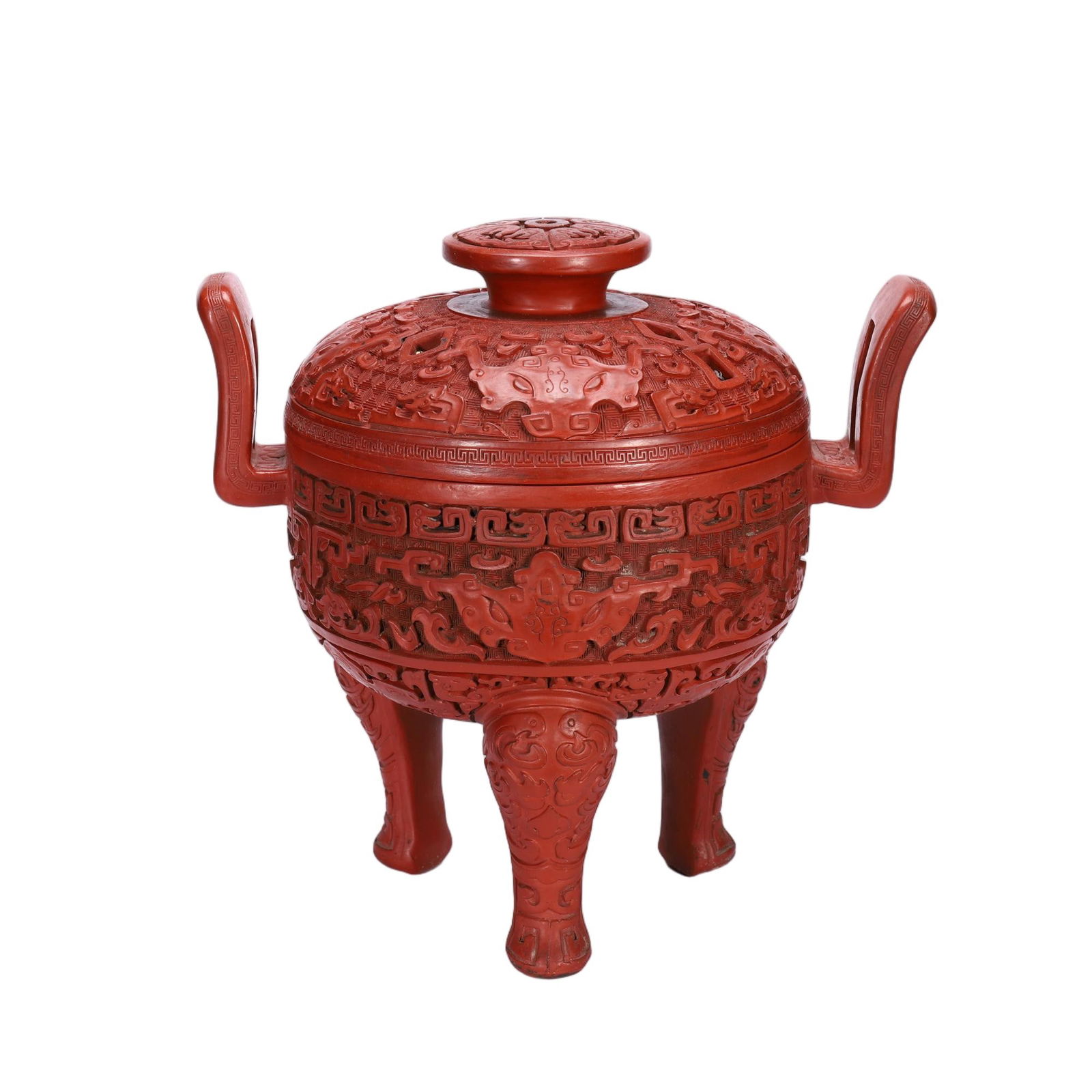 A CARVED CINNABAR LACQUER TRIPOD CENSER WITH COVER: A CARVED CINNABAR LACQUER TRIPOD CENSER WITH COVER This impressive Chinese tripod censer is crafted in vibrant red cinnabar lacquer, modeled after an archaic bronze ding. The domed cover is pierced an