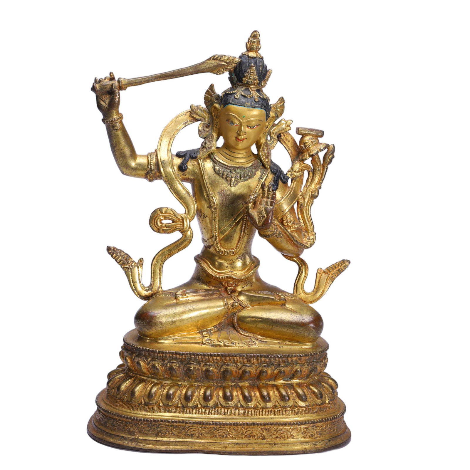 A BRONZE-GILT FIGURE OF MANJUSRI: A BRONZE-GILT FIGURE OF MANJUSRI This Chinese gilt bronze statue depicts Manjushri, the Bodhisattva of Wisdom, seated in the lotus position on a double-lotus pedestal. He holds a flaming sword aloft