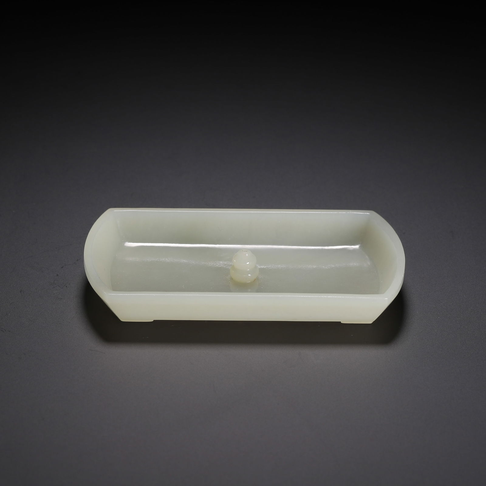A CARVED WHITE JADE INCENSE HOLDER: A CARVED WHITE JADE INCENSE HOLDER This elegant incense holder is carved from a single piece of pale, milky-white Hetian jade. It has a rectangular form with gently rounded corners, raised on four