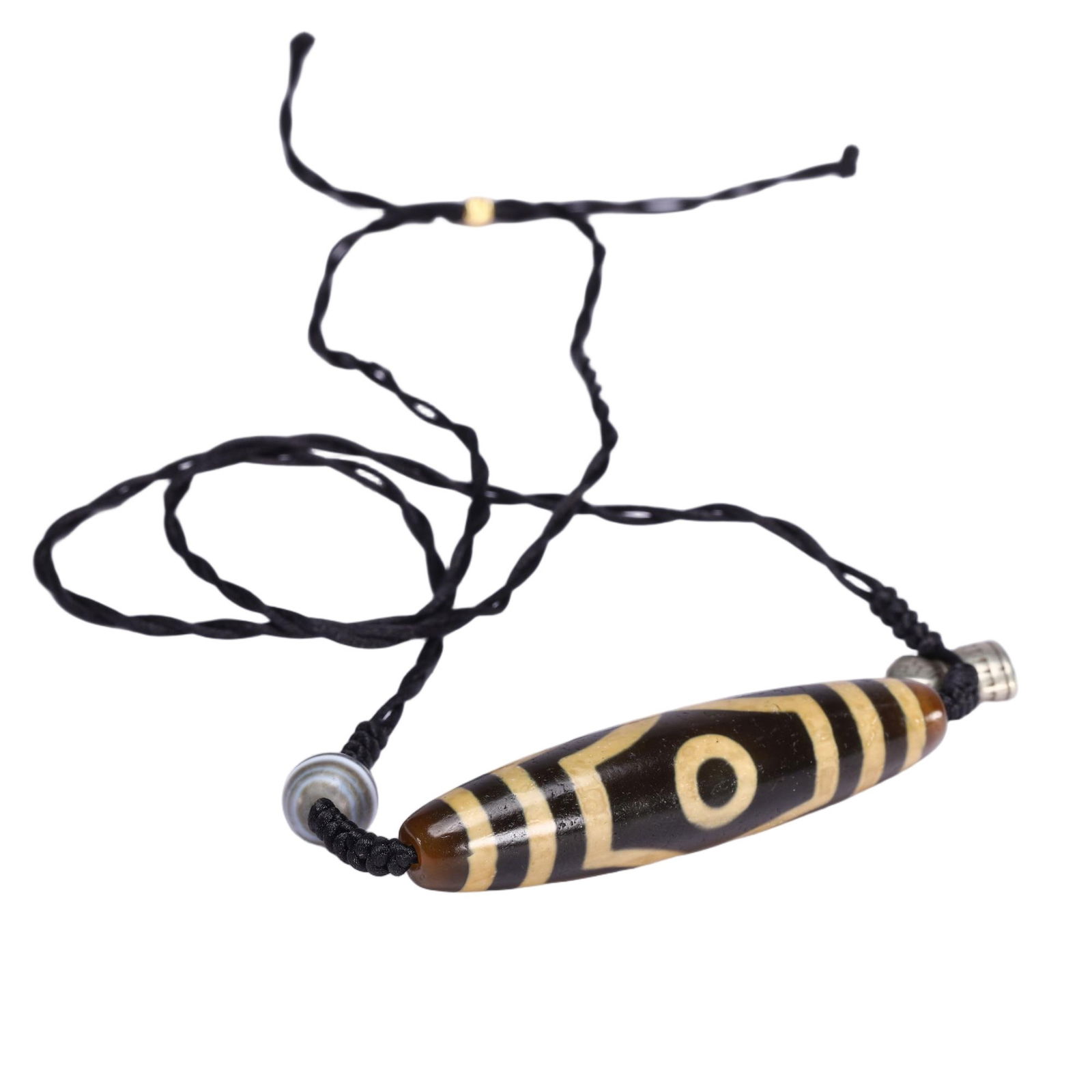 A TIBETAN DZI BEAD PENDANT: A TIBETAN DZI BEAD PENDANT This Chinese dzi bead pendant necklace features an elongated dzi bead with a dark brown base and creamy yellow inlaid patterns, including a prominent single-eye motif and ho