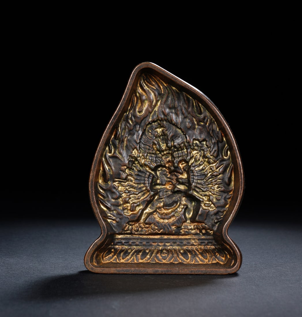 A BRONZE YAMANTAKA TSA-TSA MOLD: A BRONZE YAMANTAKA TSA-TSA MOLD A powerful Tibetan Buddhist tsa-tsa plaque, cast in bronze with a rich, dark patina and selectively gilded to highlight the intricate details of the wrathful deity at i