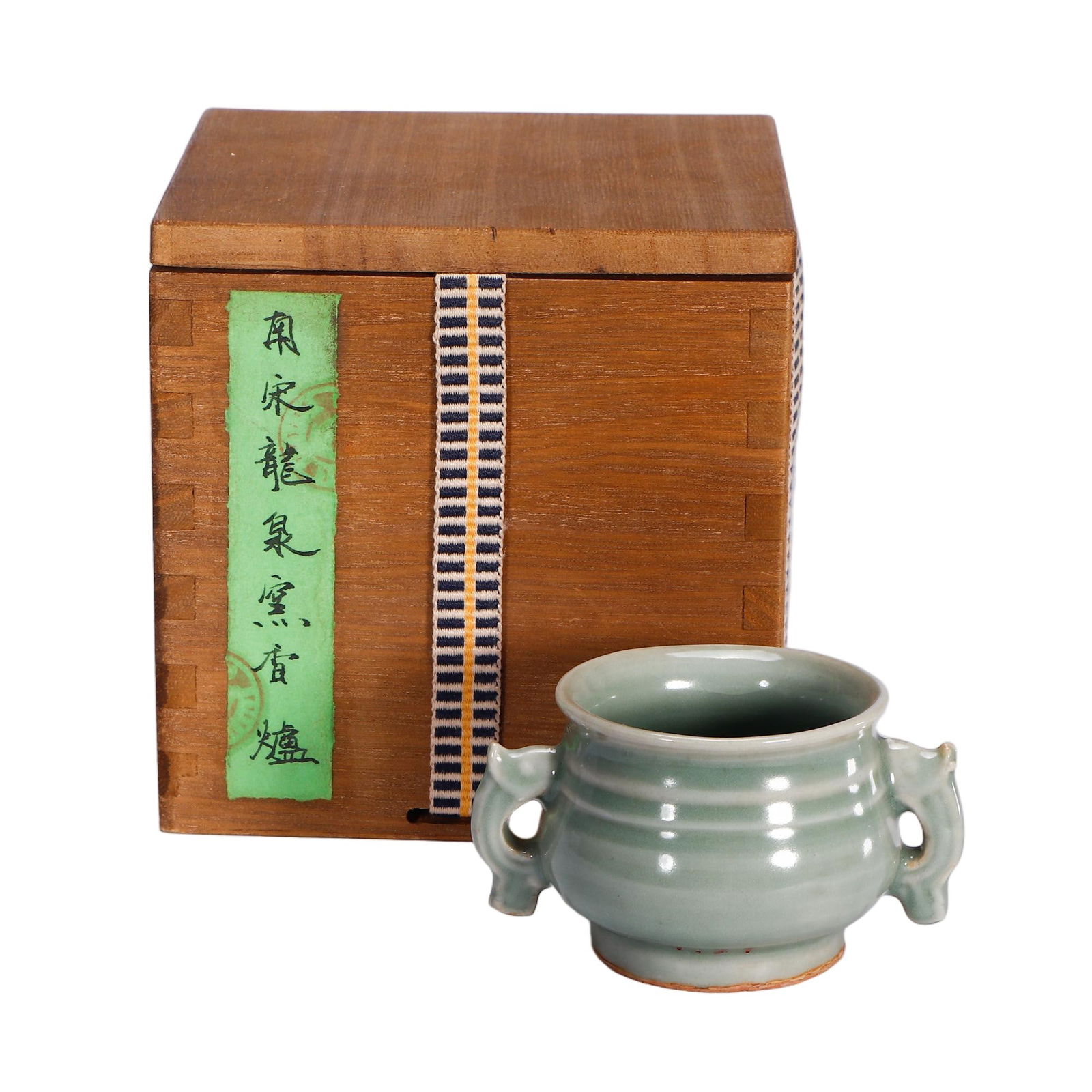 A LONGQUAN CELADON GLAZE CENSER WITH HANDLES: A LONGQUAN CELADON GLAZE CENSER WITH HANDLES This delicate Chinese censer is potted in the classic Longquan celadon style, featuring a compressed globular body raised on a short foot and flanked by