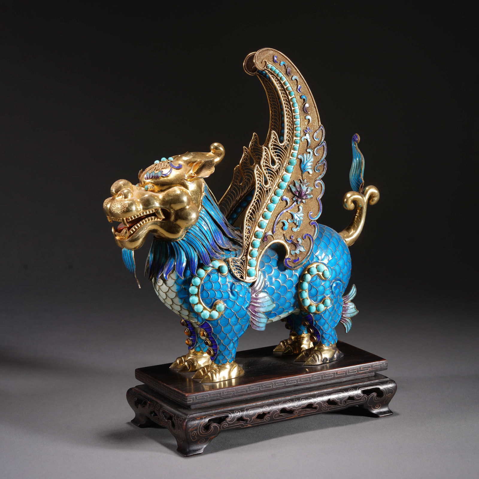 A HARDSTONES INLAID SILVER-GILT KYLIN: A HARDSTONES INLAID SILVER-GILT KYLIN A spectacular Chinese mythical qilin figure, crafted from silver and lavishly gilded, its body covered in vibrant kingfisher feather 'dian cui' scales, inset