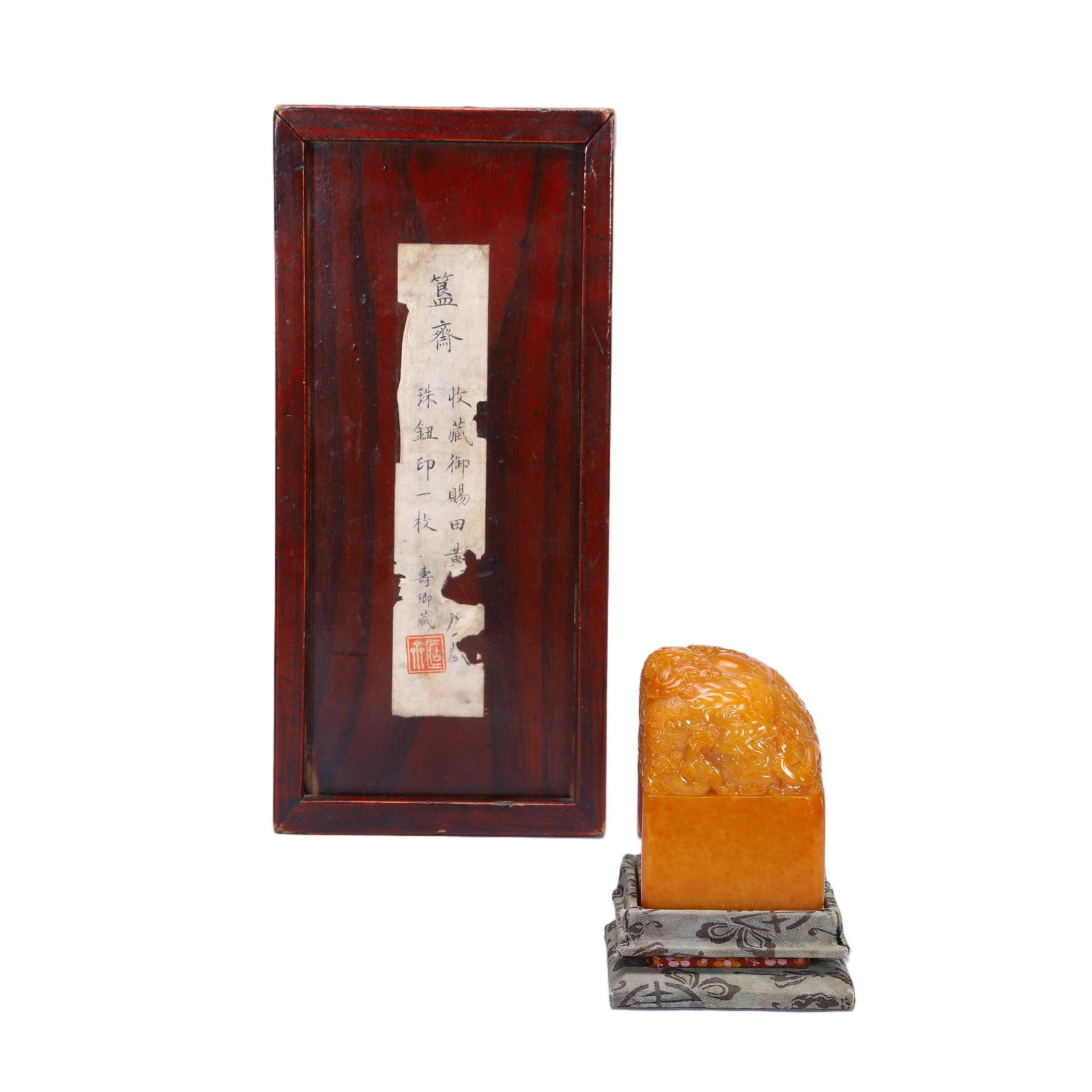 A CARVED TIANHUANG SEAL: A CARVED TIANHUANG SEAL This substantial seal is carved from a single block of fine tianhuang stone, displaying a rich, honey-amber hue with a smooth, waxy luster. The top is intricately carved in