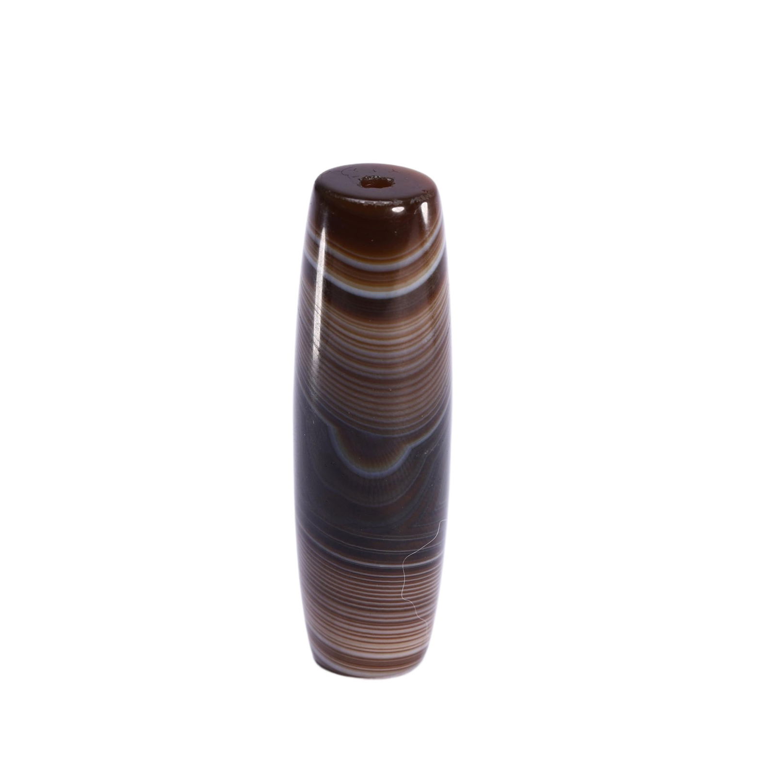 A TIBETAN DZI BEAD: A TIBETAN DZI BEAD This Chinese agate dzi bead is a fine example of traditional craftsmanship, featuring a translucent, banded agate with concentric layers of deep brown, grey, and milky white. The