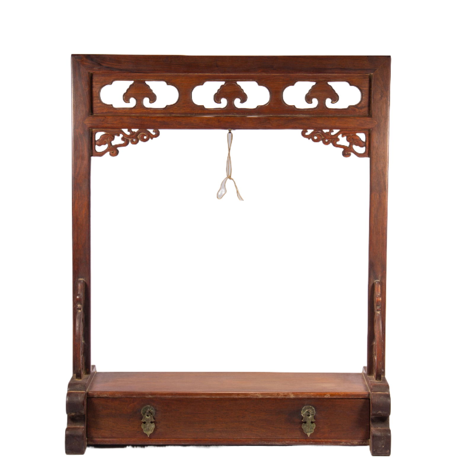 A WOODEN HUANGHUALI HANGER: A WOODEN HUANGHUALI HANGER This Chinese stand is crafted from rich, warm-toned huanghuali wood, featuring a rectangular frame with a pierced ruyi-head frieze and scrolling dragon carvings on the