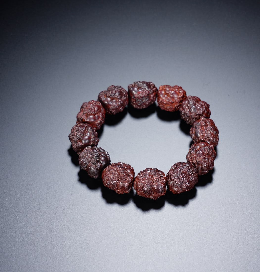 A CARVED BEADS PRAYER BEADS: A CARVED BEADS PRAYER BEADS A powerful and tactile prayer bead bracelet, composed of 12 large, deeply textured rudraksha beads, each approximately 2 cm in diameter. The beads exhibit their