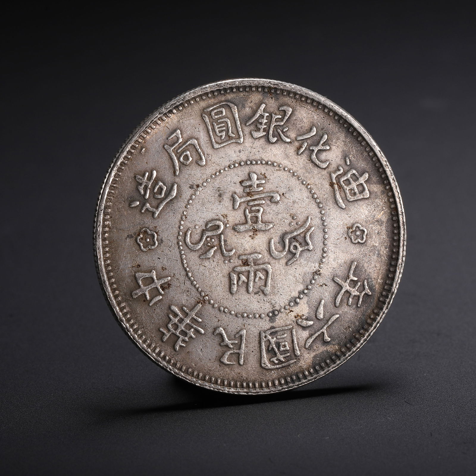 A CHINESE SILVER COIN: A CHINESE SILVER COIN A Chinese silver one-tael coin, struck with the Chinese characters '??????' (Dihua Silver Coin Bureau) and '???????' (6th Year of the Republic of China) encircling the central