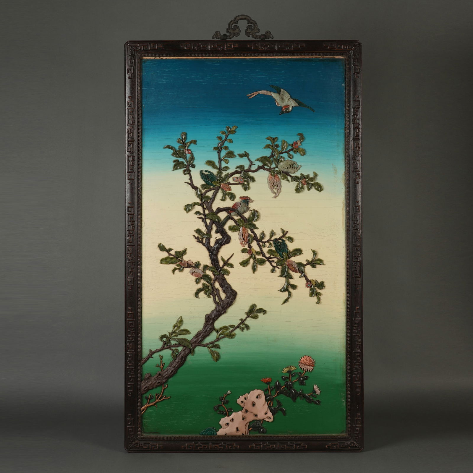 A HARDSTONES INLAID LACQUER HANGING PANEL: A HARDSTONES INLAID LACQUER HANGING PANEL An elegant Chinese hanging panel, set within a carved hongmu frame with a key-fret border. The polychrome ground, graduating from sky-blue to cream and vibran