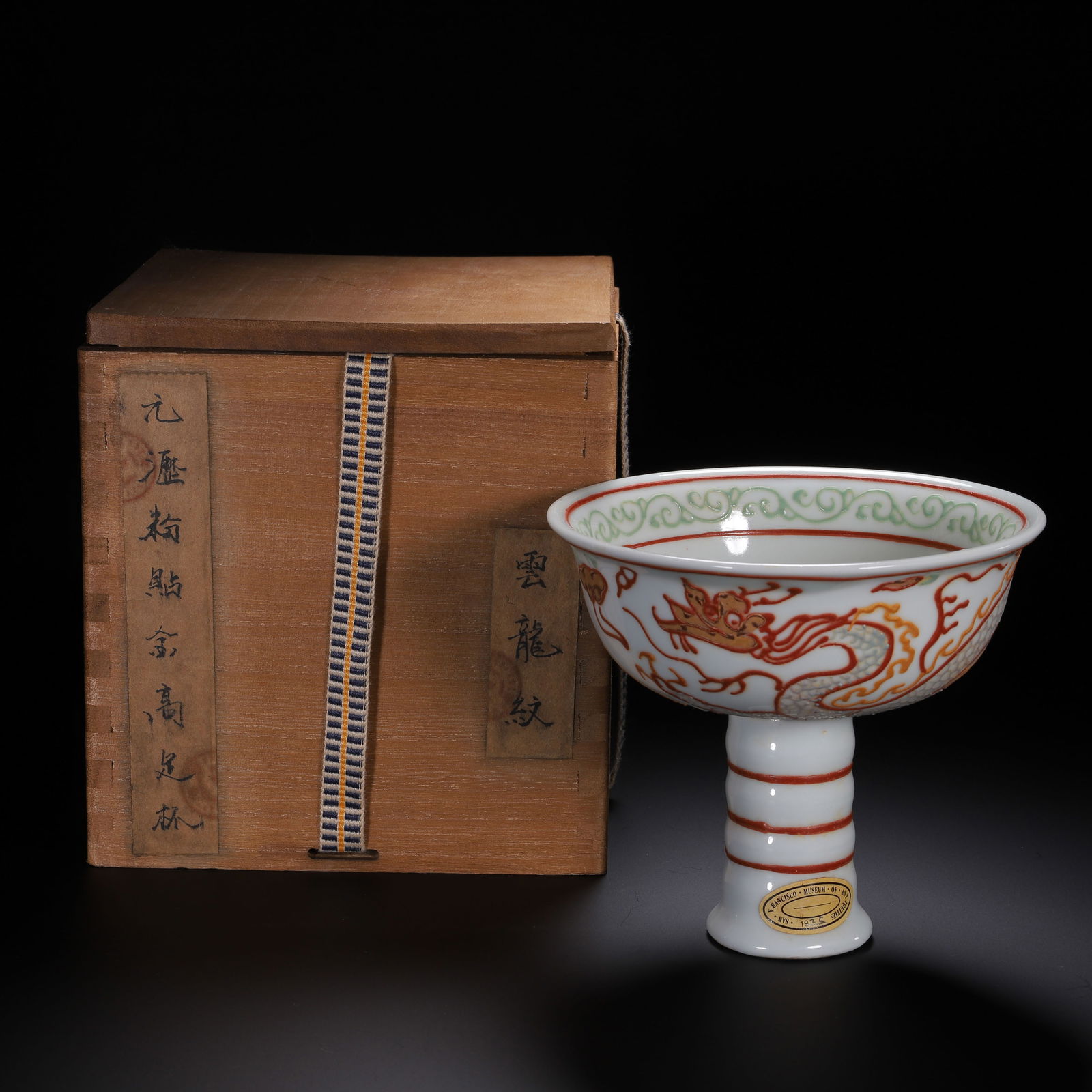 A CHINESE ENAMELED DRAGON STEAM CUP: A CHINESE ENAMELED DRAGON STEAM CUP This elegant Chinese stem cup features a flared bowl and a tall, segmented stem. It is vividly decorated with a dynamic dragon in pursuit of a flaming pearl,