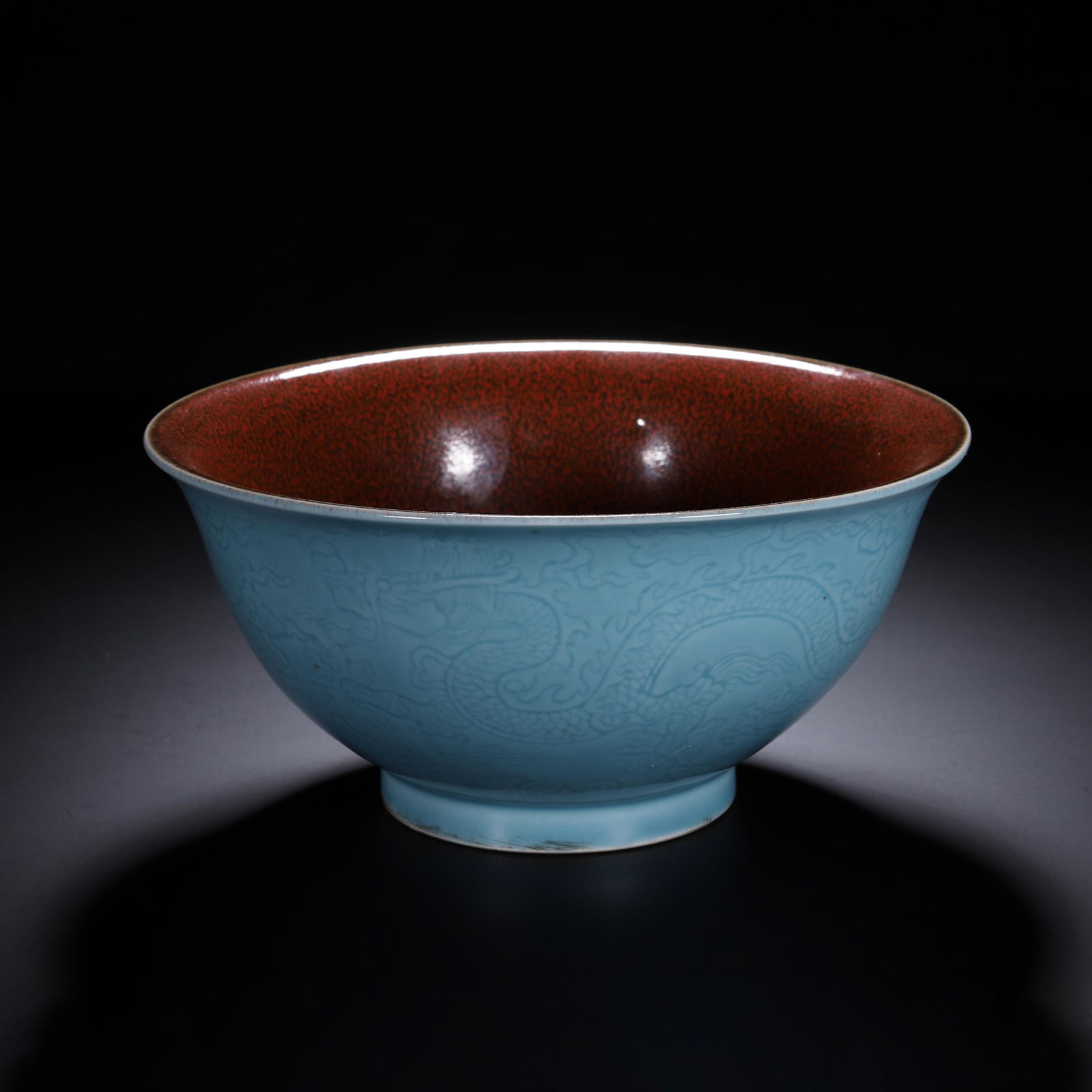 AN INCISED BLUE GLAZE DRAGON BOWL: AN INCISED BLUE GLAZE DRAGON BOWL A Chinese turquoise-glazed porcelain bowl, with a flared rim and a short, rounded foot. The exterior is decorated with a finely incised, anhua dragon pattern coiling