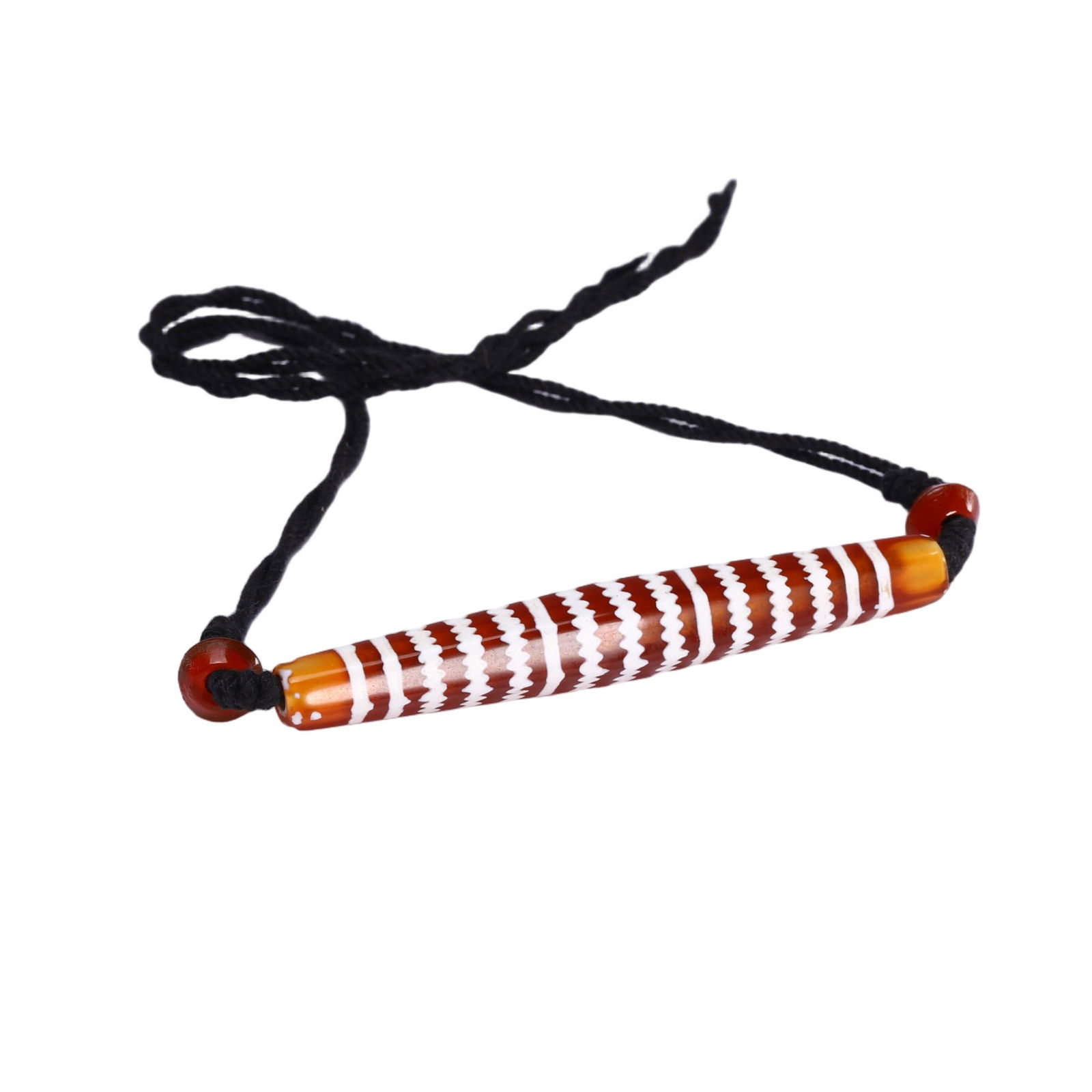 A TIBETAN DZI BEAD PENDANT: A TIBETAN DZI BEAD PENDANT This Chinese carnelian dzi bead pendant necklace features an elongated, tapered bead with a rich, translucent orange-red base, adorned with crisp white inlaid zigzag and