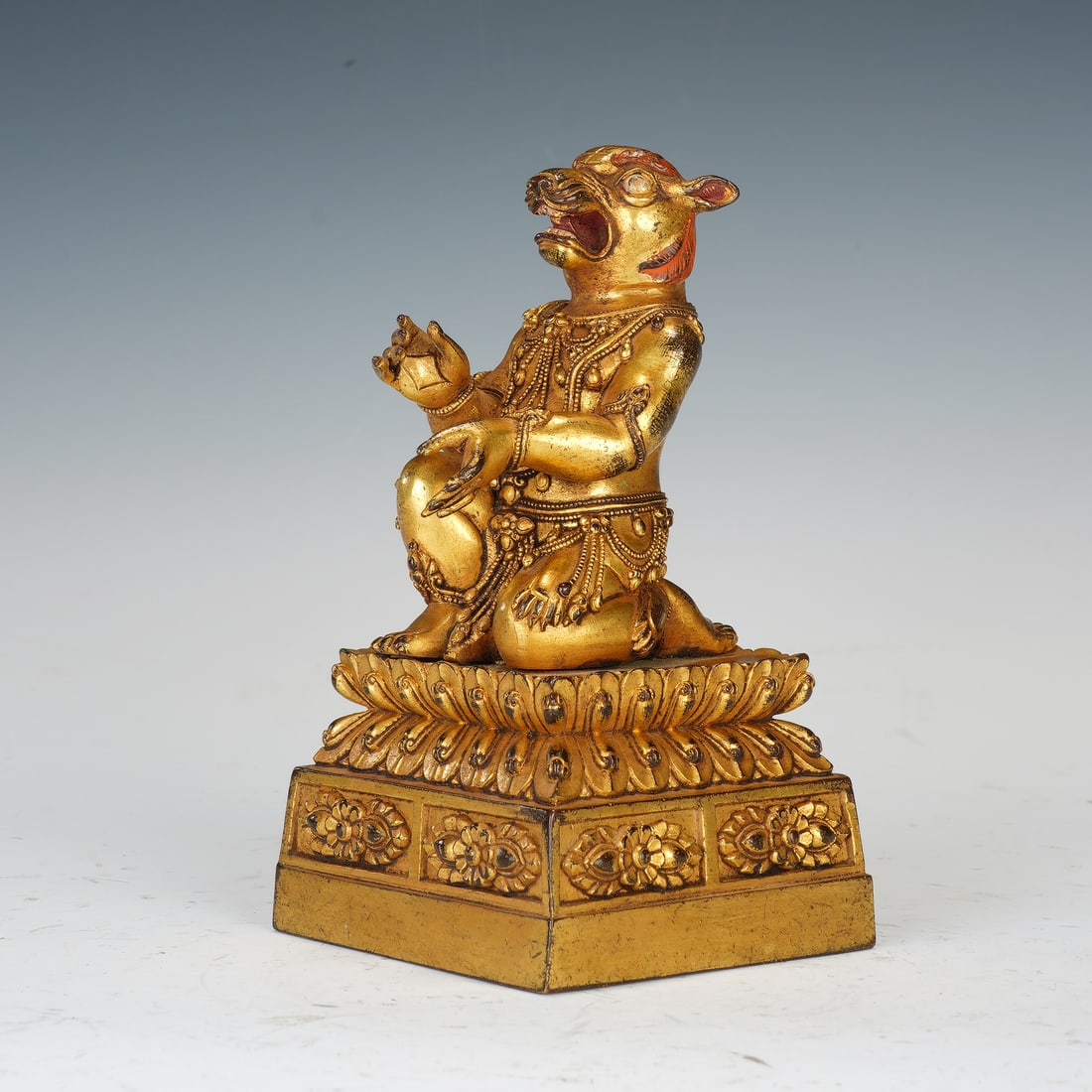 A BRONZE-GILT GUARDIAN SEAL: A BRONZE-GILT GUARDIAN SEAL An exceptional and rare Tibetan Buddhist seal, cast in bronze and lavishly gilded. The square base is surmounted by a powerful kneeling figure of a Dakini with a boar's hea