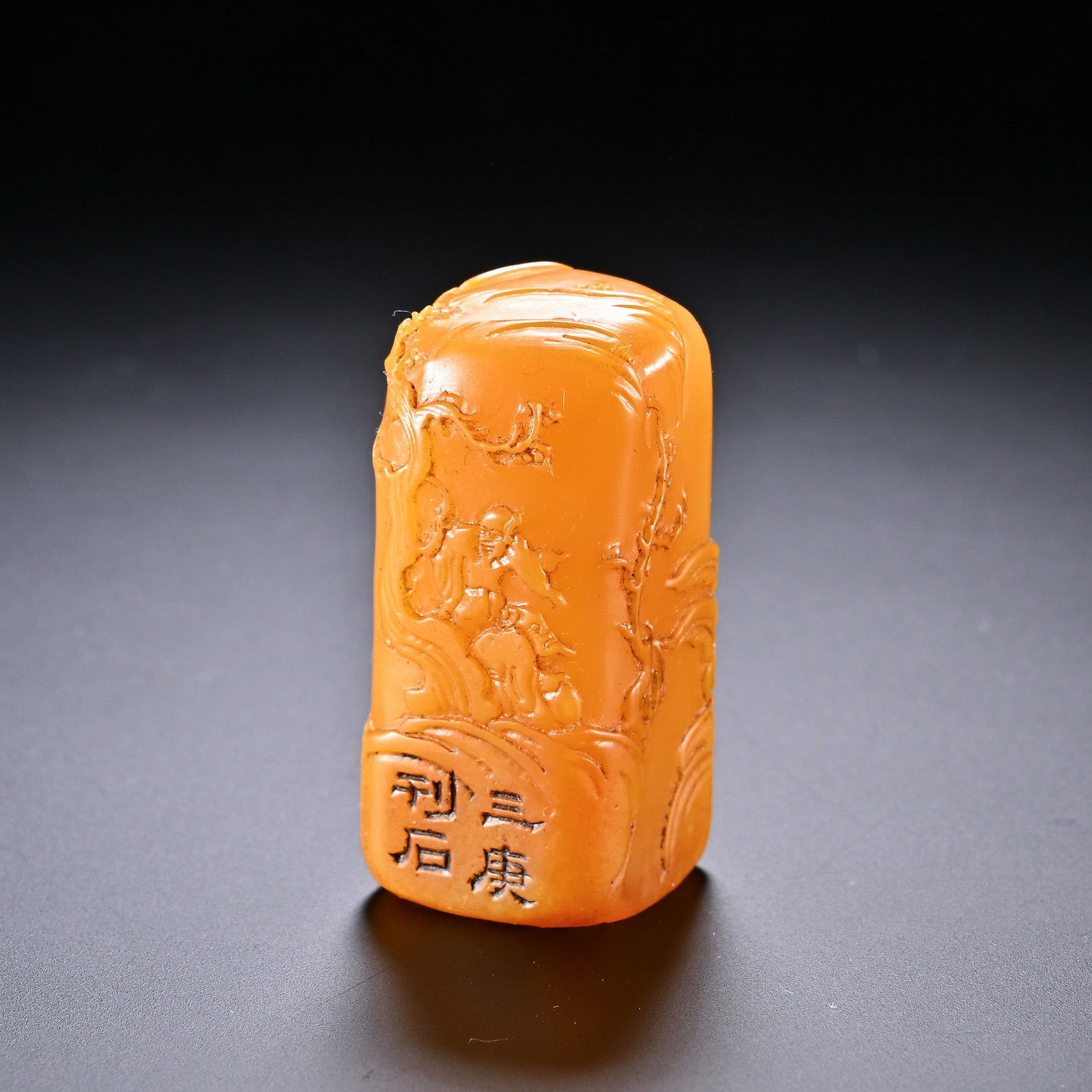 A Chinese Tianhuang Stone Seal: A Chinese Tianhuang Stone Seal This finely carved Tianhuang stone seal, measuring 4.2 cm in height and 2 cm in width, features a rich, warm orange hue and a smooth, polished surface. The body is adorn