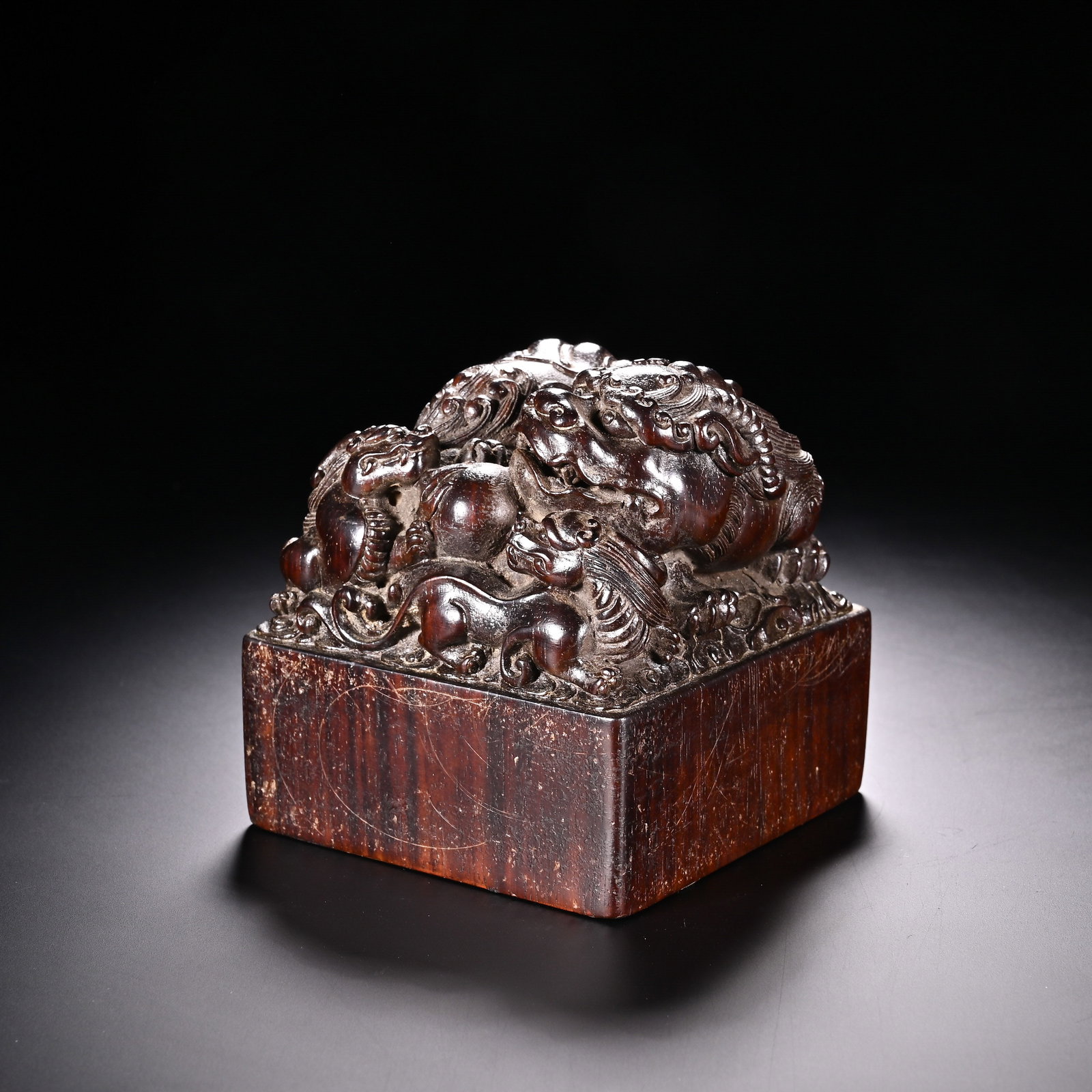 A Chinese Zitan Wood Seal with Dragon and Lion Carving: A Chinese Zitan Wood Seal with Dragon and Lion Carving This impressive square zitan wood seal, measuring 8.2 cm in height and 8 cm in width, is crafted from richly grained dark zitan wood with a deep,