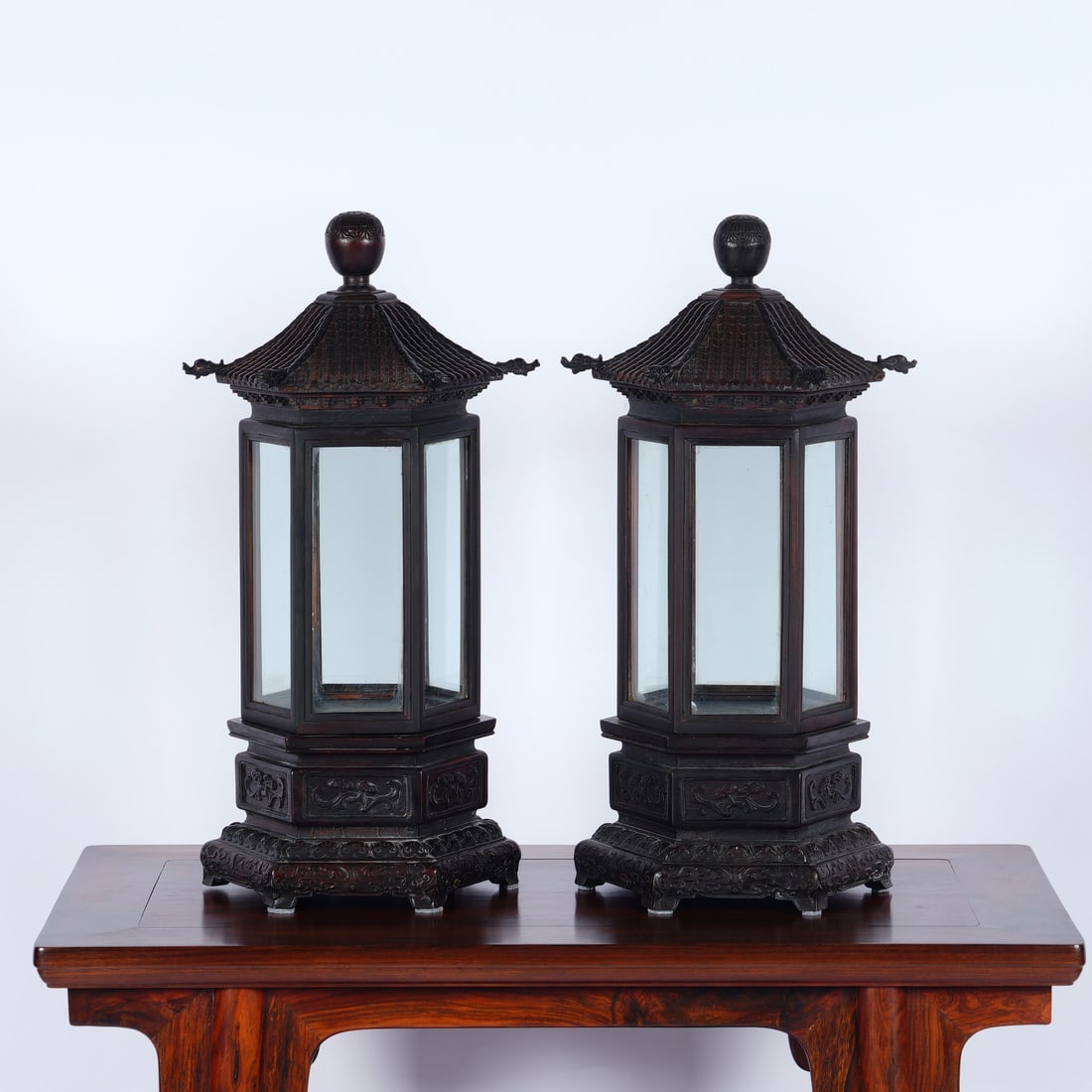 A Pair of Chinese Zitan Wood Shrines: A Pair of Chinese Zitan Wood Shrines This elegant pair of hexagonal shrines is crafted from solid zitan wood, designed in the form of miniature pagodas. Each features a tiered roof topped with a finia