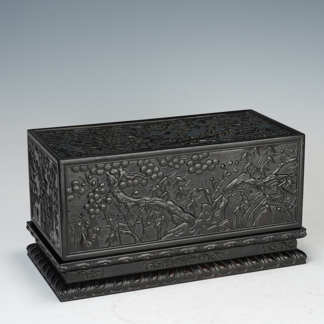 Chinese Zitan Wood Carved Box: Chinese Zitan Wood Carved Box This rectangular box is crafted from solid zitan wood, its entire surface deeply carved with continuous relief scenes of pine, bamboo, and plum blossoms, the ?Three Frien