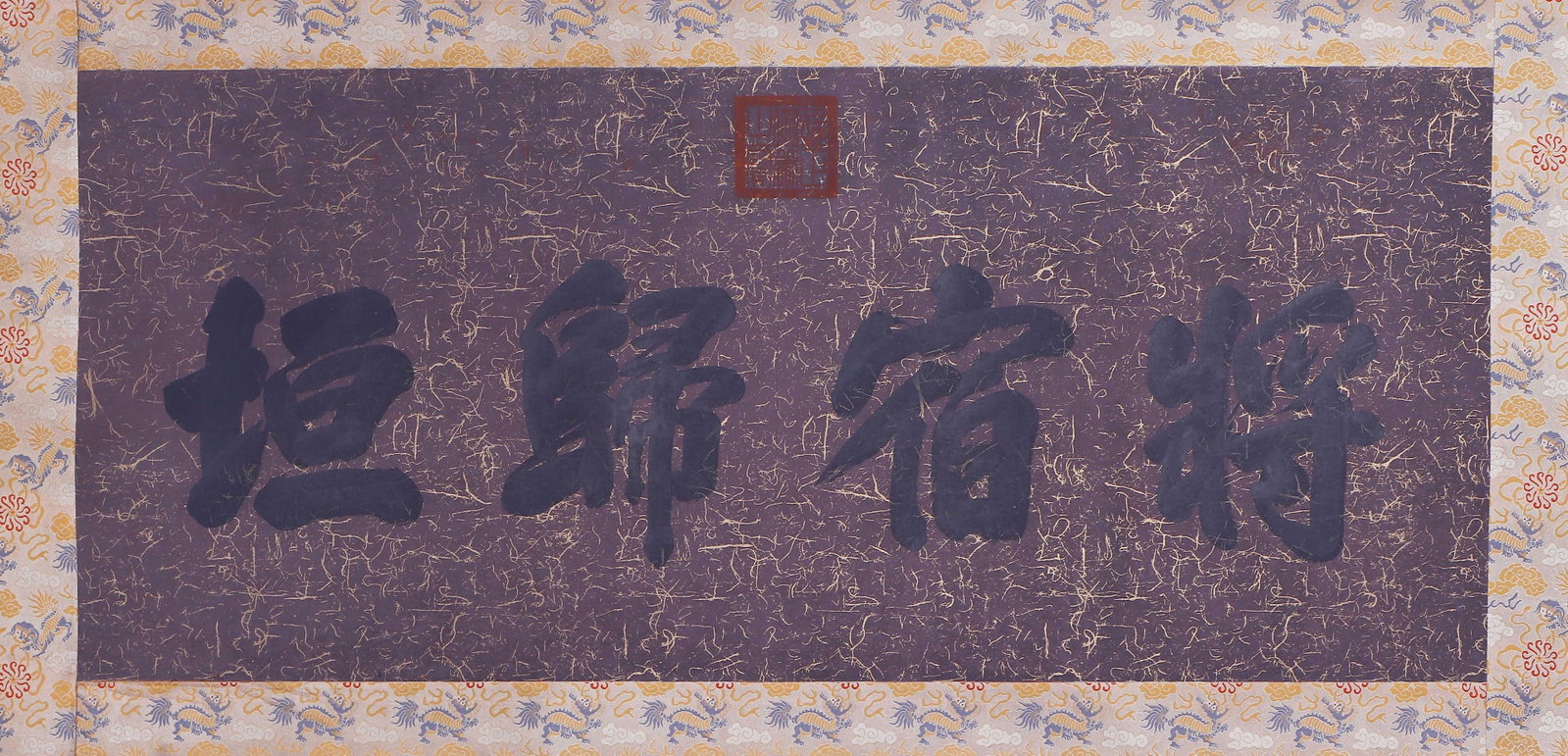 A CHINESE CALLIGRAPHY: A CHINESE CALLIGRAPHY This striking horizontal calligraphy features four large characters ?Jiang Su Gui Yuan? rendered in bold, fluid script on rich purple speckled paper. Mounted with an ornate patte