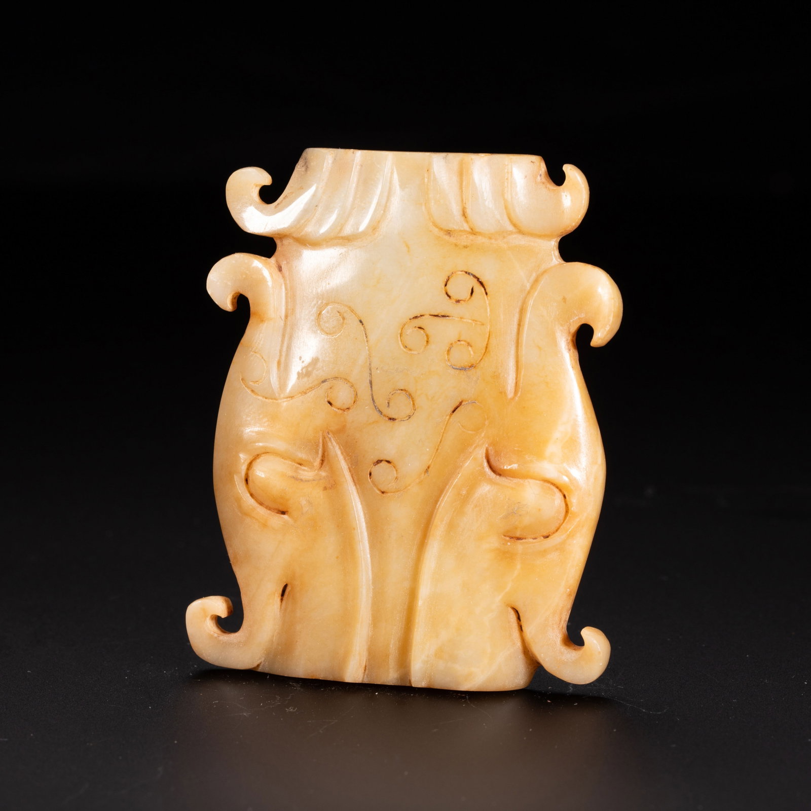 A Chinese Hetian Jade Bixie Pendant: A Chinese Hetian Jade Bixie Pendant A finely carved Chinese Hetian jade pendant depicting a stylized bixie, the mythical guardian beast. The warm honey-toned stone bears natural russet inclusions and 