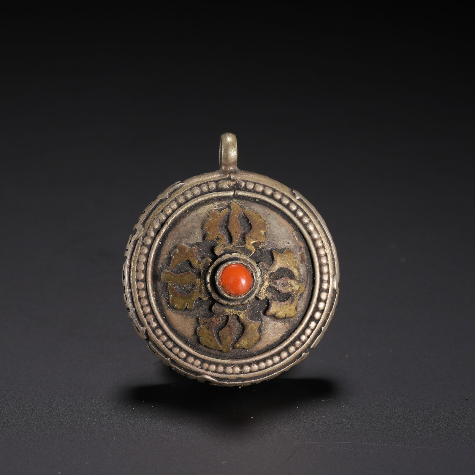 Chinese Tibetan Silver Gau Prayer Amulet Box: Chinese Tibetan Silver Gau Prayer Amulet Box A small circular Tibetan silver gau pendant, crafted with a hinged locket design for holding sacred relics. The front is adorned with a gilded double-vajra