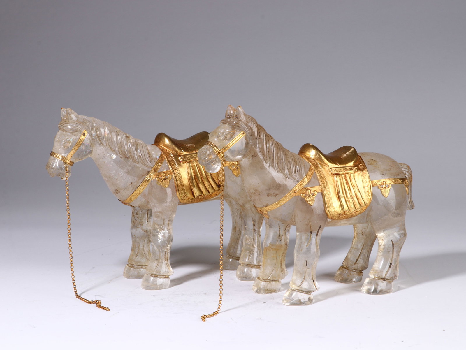 A Pair of Chinese Rock Crystal Horses with Gilt-Bronze Trappings: A Pair of Chinese Rock Crystal Horses with Gilt-Bronze Trappings This elegant pair of horses, each measuring 16.5 cm in height and 22 cm in width, are masterfully carved from translucent rock crystal.