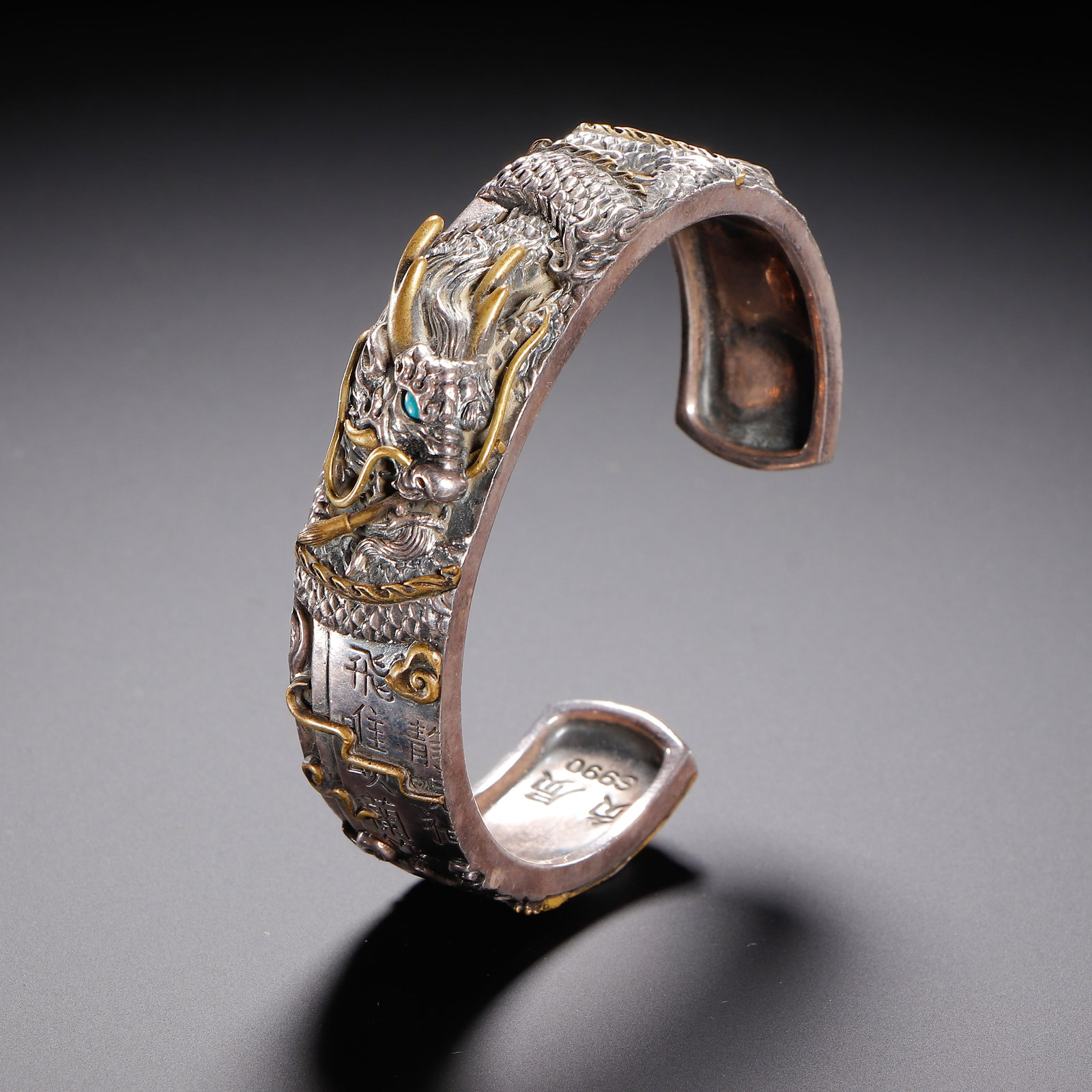 A Chinese Gilt Silver Dragon Bangle: A Chinese Gilt Silver Dragon Bangle This Chinese gilt silver dragon bangle measures 6.5 cm in length, 6.5 cm in width, 6.5 cm in height, and weighs 67 grams. Crafted from silver marked "S990," the ope
