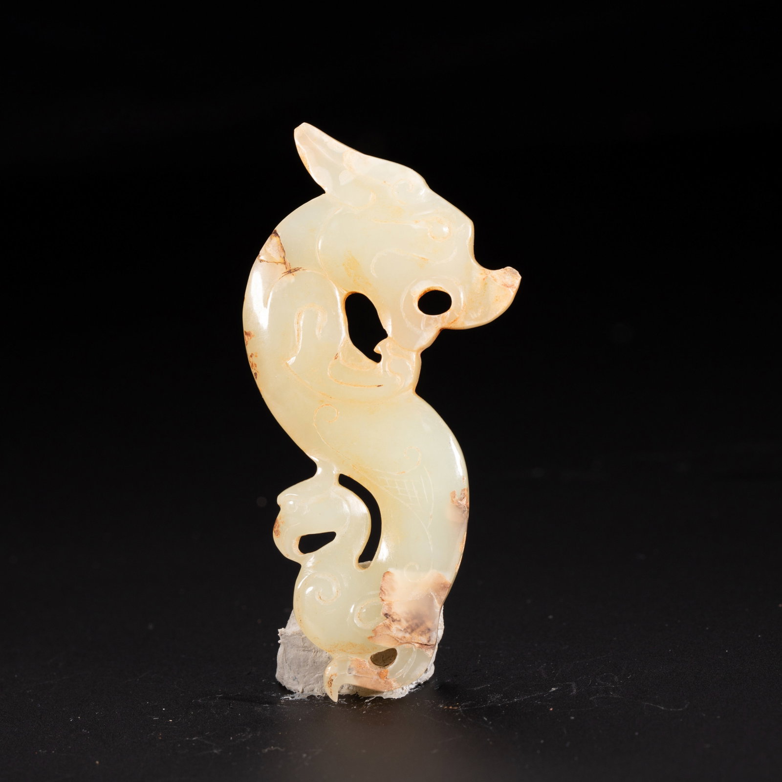 A Chinese Hetian Jade Chilong Dragon Pendant: A Chinese Hetian Jade Chilong Dragon Pendant This is a finely carved Chinese Hetian jade pendant depicting a stylized chilong dragon in a dynamic, sinuous form, executed with delicate openwork. The pa