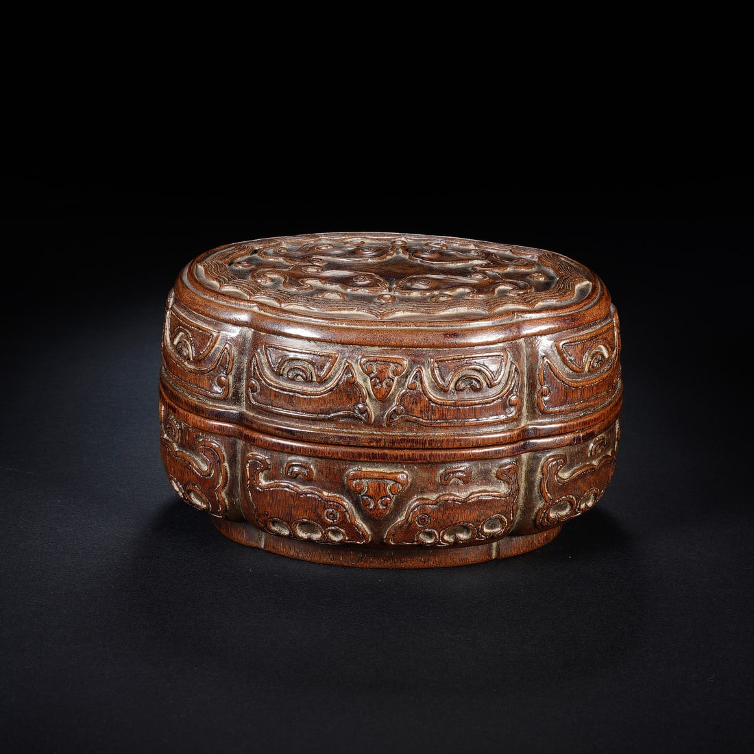Chinese Agarwood Carved Covered Box: Chinese Agarwood Carved Covered Box This finely carved covered box is expertly crafted from solid agarwood, showcasing a rich, aged patina. The surface is adorned with intricate relief carvings of arc
