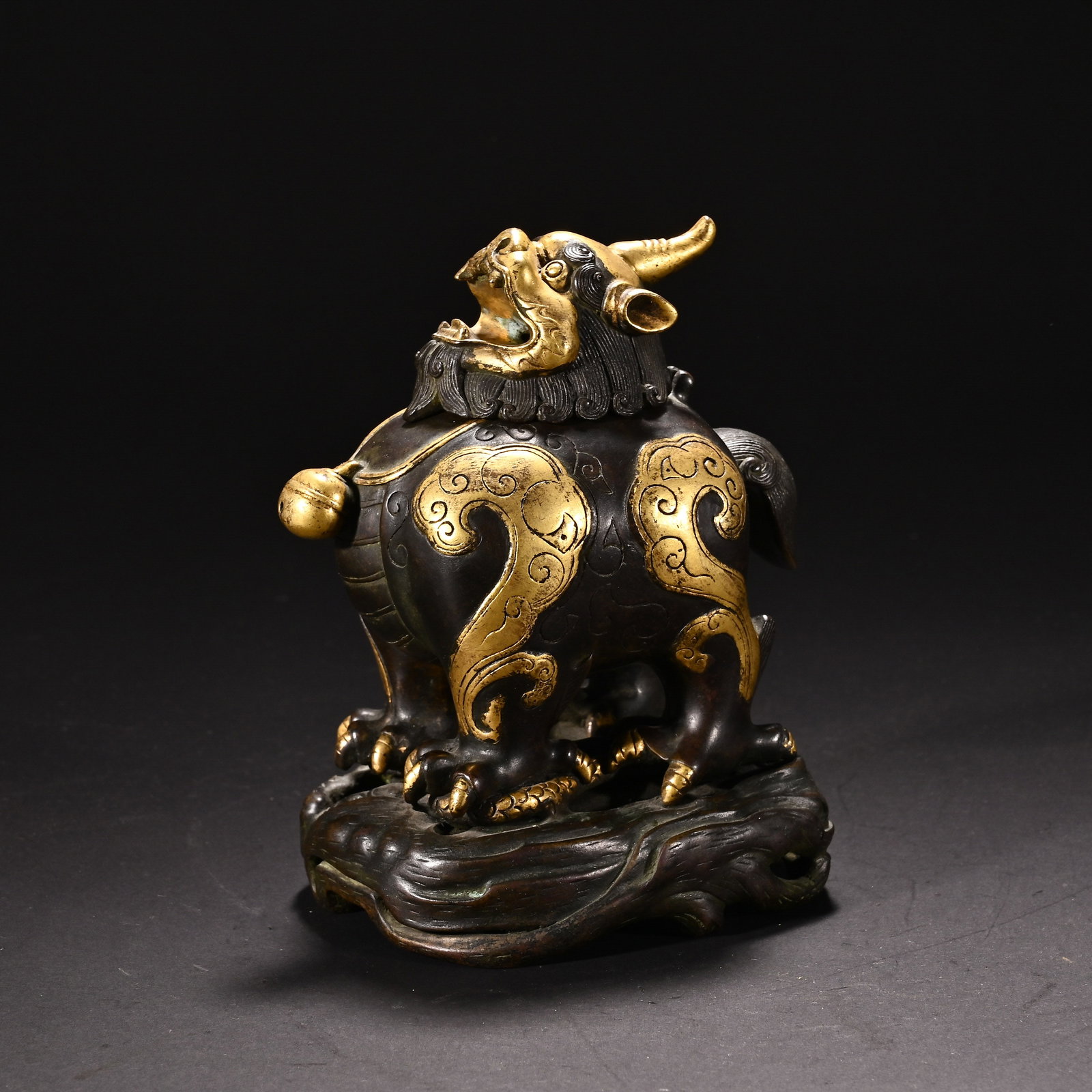 A Chinese Parcel-Gilt Bronze Luduan Censer: A Chinese Parcel-Gilt Bronze Luduan Censer This striking parcel-gilt bronze luduan censer, measuring 13.4 cm in height and 11 cm in width, depicts the mythical beast in a powerful, alert pose. The bod