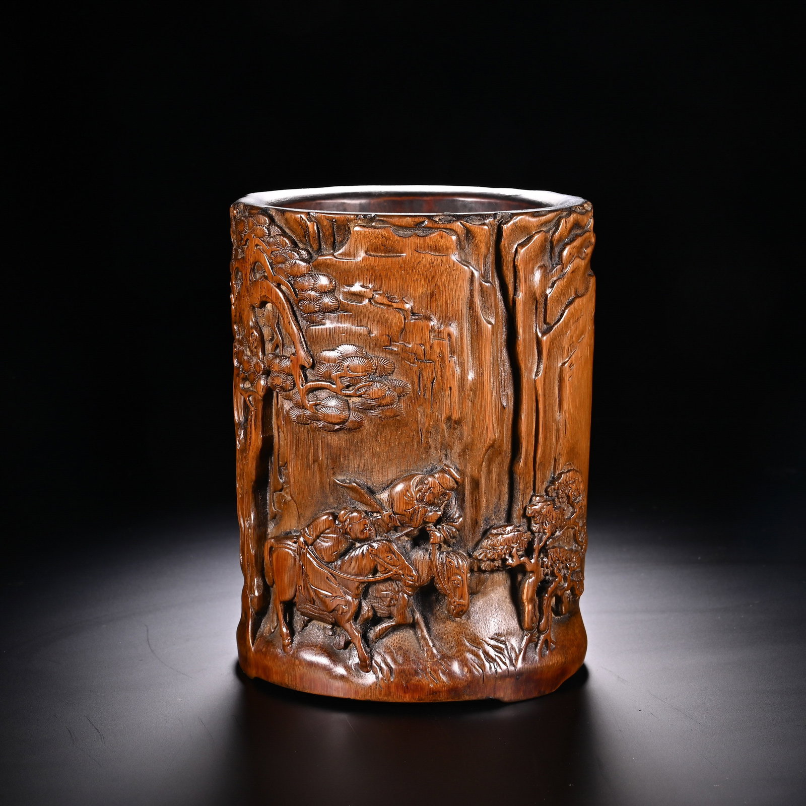 A Chinese Bamboo Brush Pot with Deep-Relief Landscape and Figural Carving: A Chinese Bamboo Brush Pot with Deep-Relief Landscape and Figural Carving This masterfully carved bamboo brush pot, measuring 14 cm in height and 11 cm in width, features a rich, warm patina that high