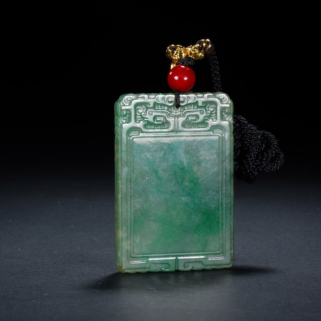 Chinese Jadeite Square Pendant: Chinese Jadeite Square Pendant This elegant Chinese jadeite pendant is finely carved in the form of a rectangular plaque, featuring stylized dragon motifs along the top and bottom borders. The central