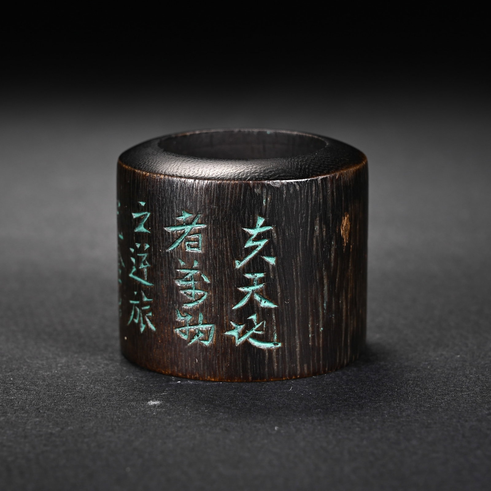 A CHINESE AGARWOOD THUMB RING WITH INSCRIBED POEM: A CHINESE AGARWOOD THUMB RING WITH INSCRIBED POEM This cylindrical archer's thumb ring is crafted from fine agarwood with distinct vertical natural wood grain and a deep dark aged patina. Its outer su