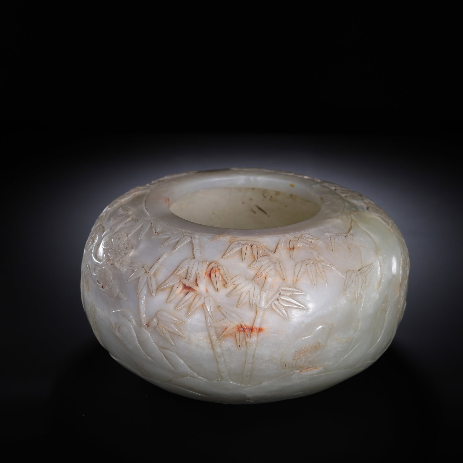 A CHINESE HETIAN JADE BRUSH WASHER: A CHINESE HETIAN JADE BRUSH WASHER This rounded globular scholar's water basin is carved from pale Hetian nephrite jade, retaining natural russet skin streaks across the polished exterior. The surface