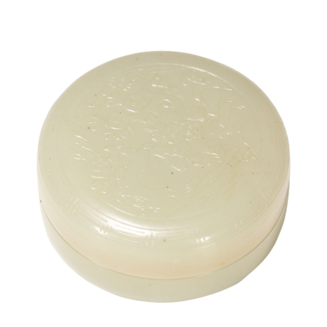 A CHINESE WHITE HETIAN NEPHRITE CIRCULAR LIDDED BOX: A CHINESE WHITE HETIAN NEPHRITE CIRCULAR LIDDED BOX This compact circular cosmetic box is carved from creamy pale Hetian jade with a smooth velvety polish and faint natural mineral speckles across the
