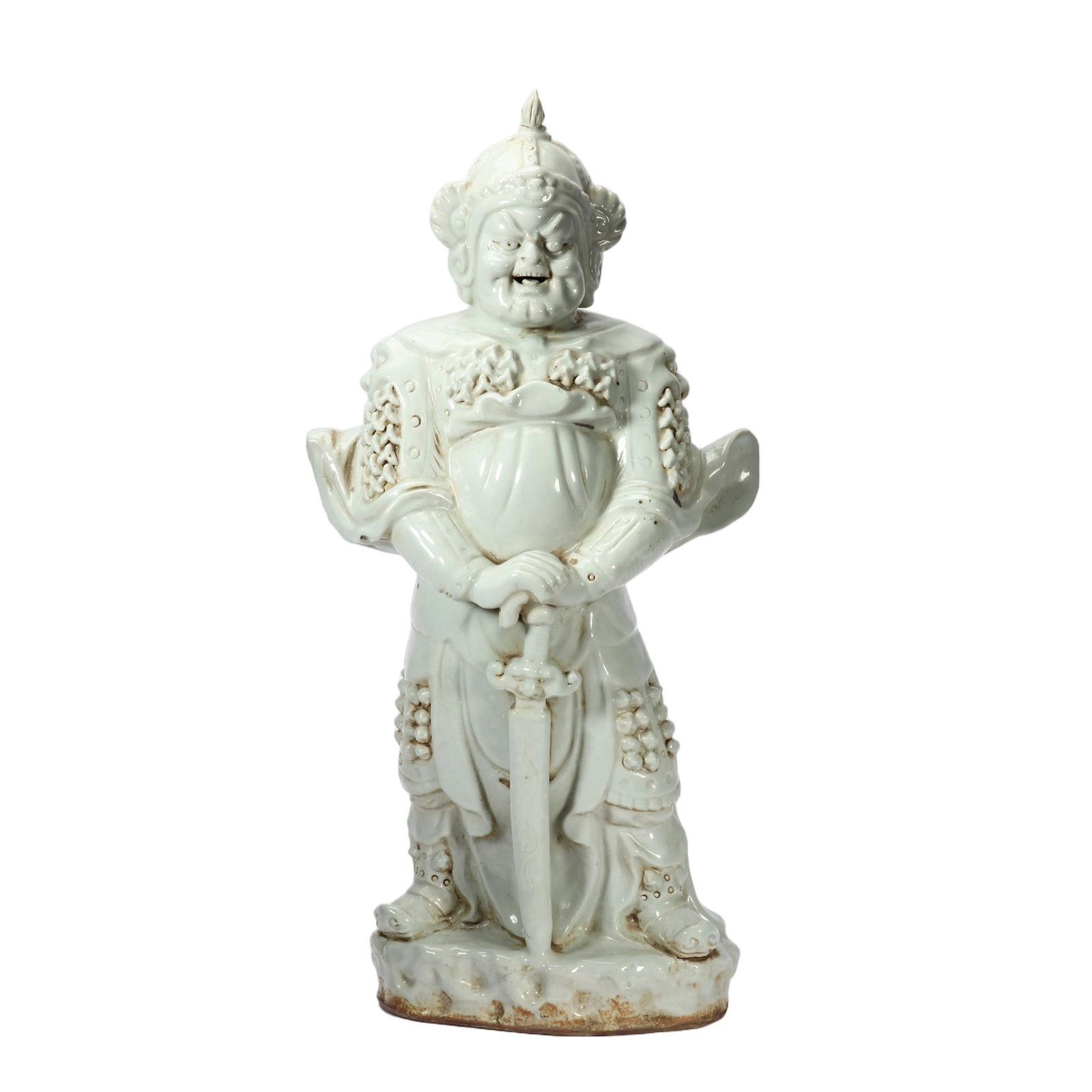 A CHINESE BLANC DE CHINE PORCELAIN GUARDIAN WARRIOR FIGURE: A CHINESE BLANC DE CHINE PORCELAIN GUARDIAN WARRIOR FIGURE This imposing standing guardian general is fully glazed in smooth creamy blanc de Chine white glaze, mounted atop an irregular rocky plinth w