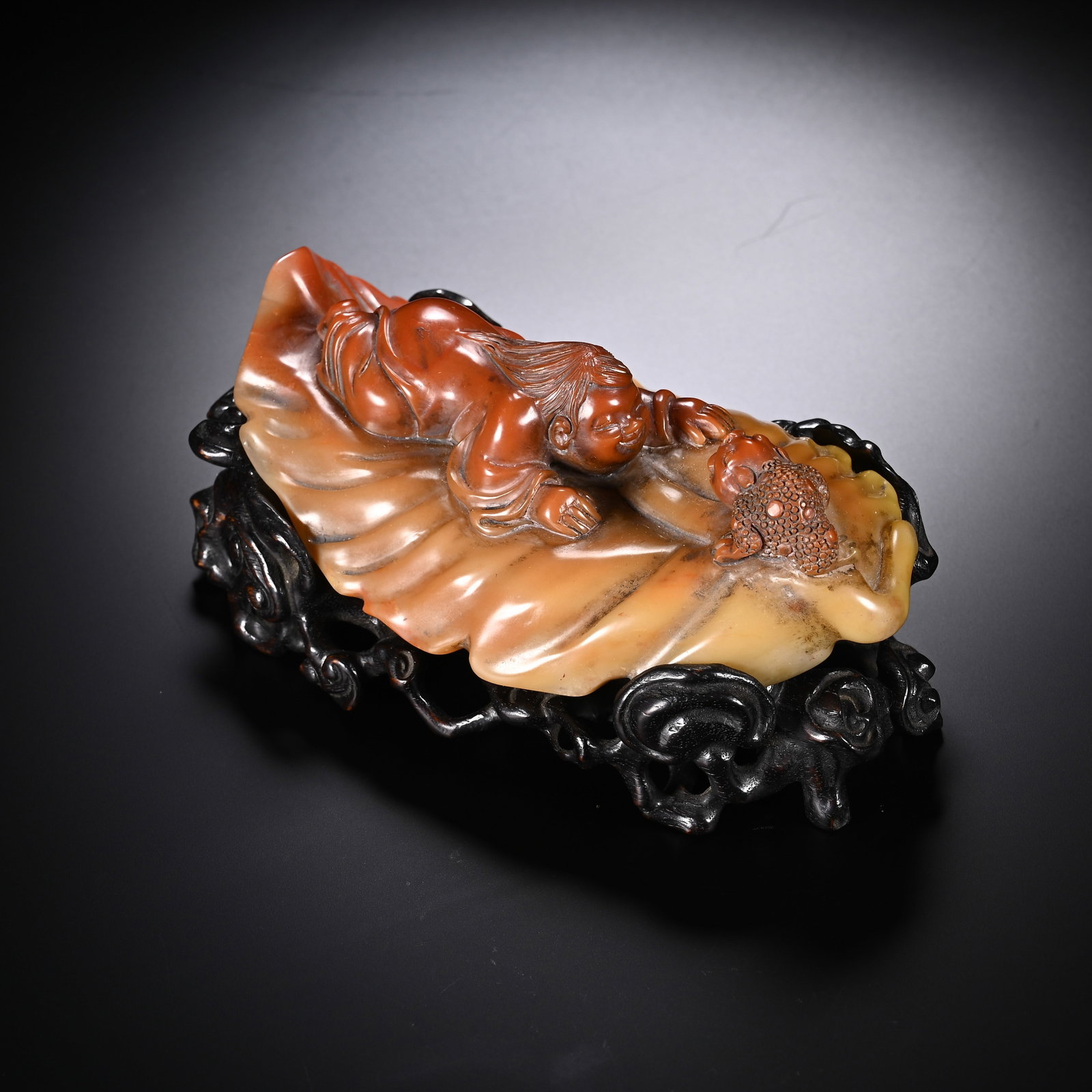 A CHINESE SHOUSHAN STONE LIU HAI AND GOLDEN TOAD CARVING: A CHINESE SHOUSHAN STONE LIU HAI AND GOLDEN TOAD CARVING This ornamental carving is shaped from natural variegated Shoushan stone with blended warm red and creamy yellow hues. The stone is