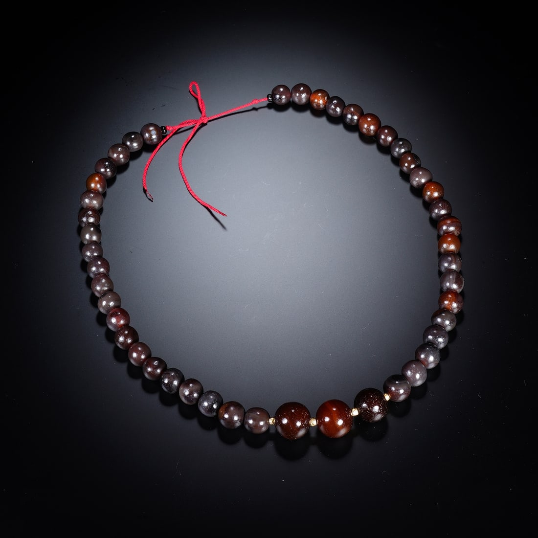 A CHINESE ANTIQUE BANDED AGATE BEAD STRAND: A CHINESE ANTIQUE BANDED AGATE BEAD STRAND This antique bead strand is strung with polished rounded agate beads graduating in size, with the central focal beads reaching 2 cm in diameter. The stones d