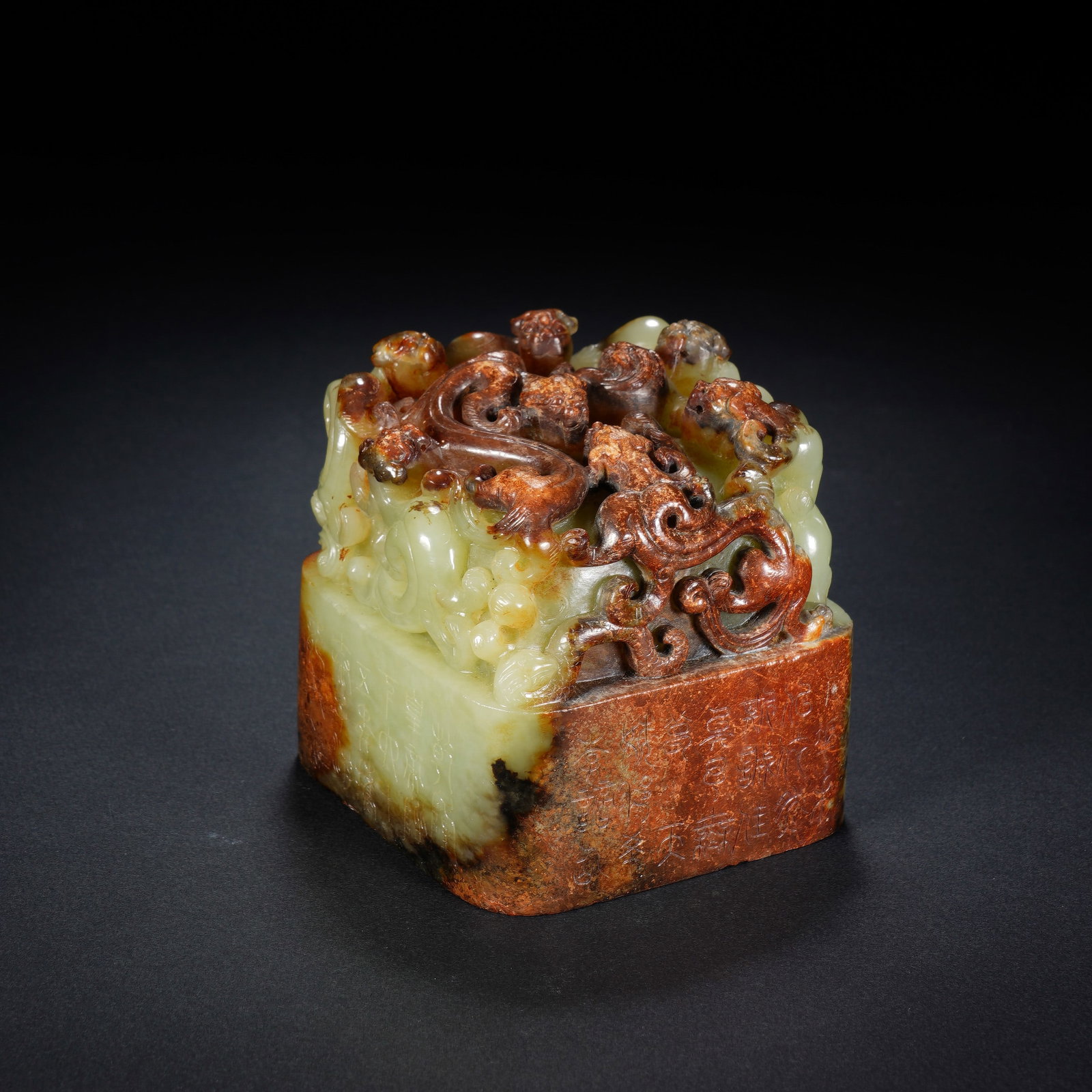 A CHINESE ARCHAIC JADE SEAL WITH CHILONG FINIAL: A CHINESE ARCHAIC JADE SEAL WITH CHILONG FINIAL This square jade seal measures 8cm ? 8cm ? 8cm and weighs 973 grams, carved from pale celadon jade naturally streaked with rich russet skin across one v