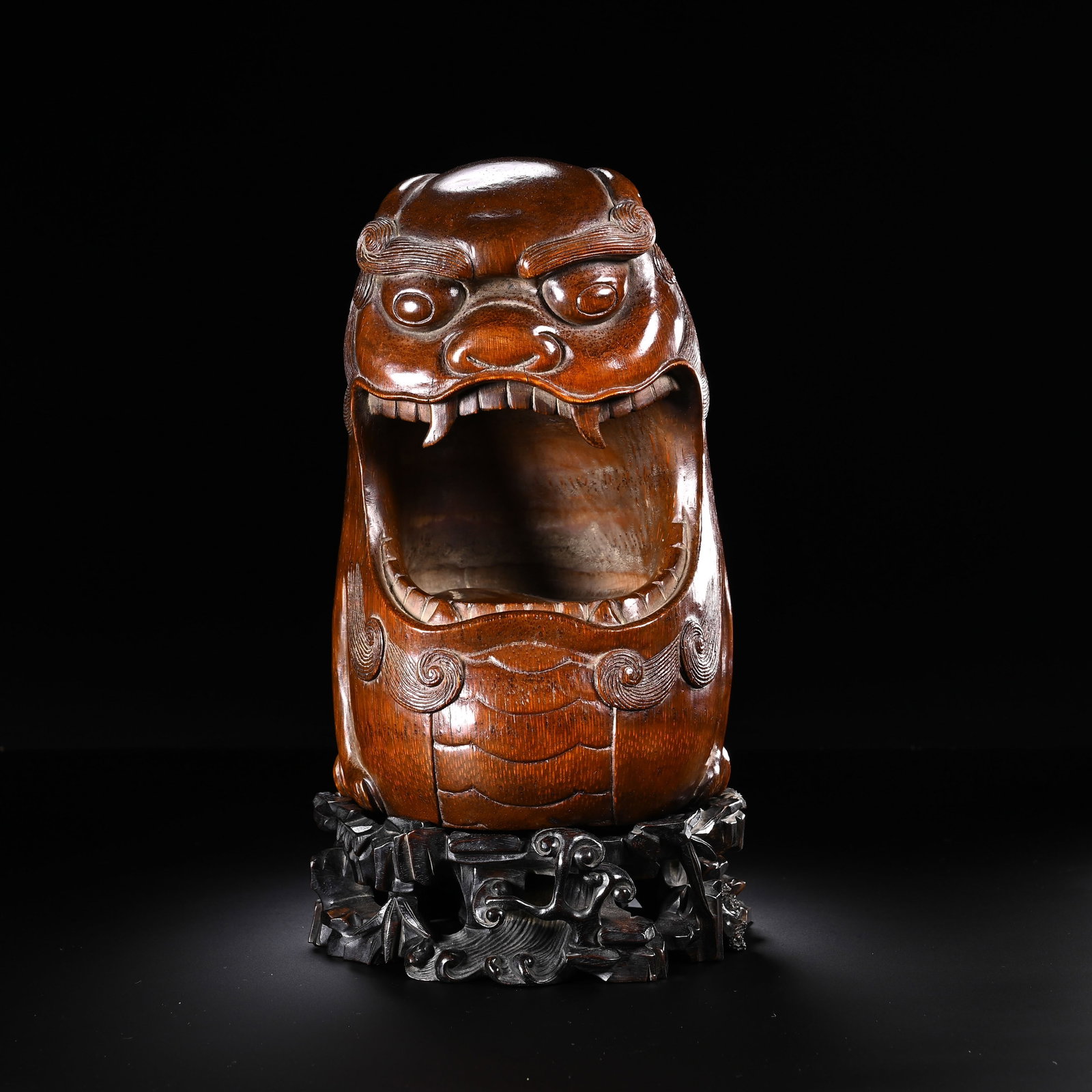 A CHINESE CARVED BAMBOO MYTHICAL BEAST CENSER: A CHINESE CARVED BAMBOO MYTHICAL BEAST CENSER Crafted from a solid aged bamboo root, this incense burner takes the form of a stout auspicious mythical beast with a wide open maw serving as the smoke o