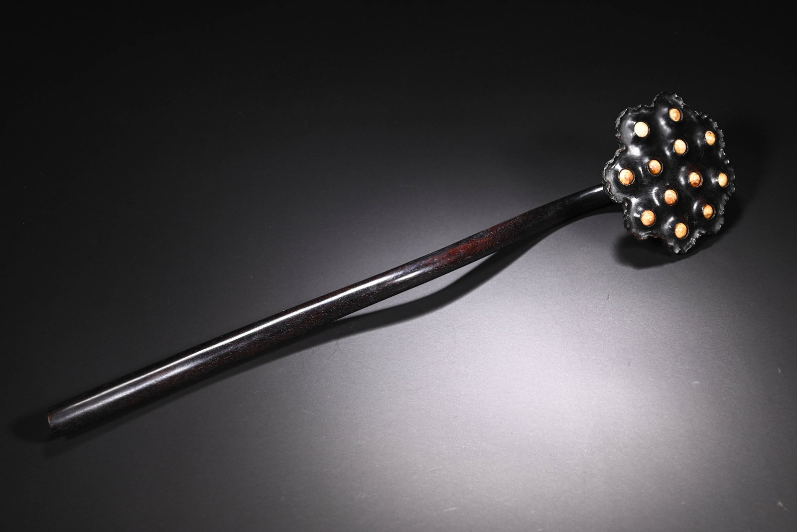 A CHINESE ZITAN WOOD LOTUS SEEDPOD RUYI SCEPTER: A CHINESE ZITAN WOOD LOTUS SEEDPOD RUYI SCEPTER This ceremonial ruyi scepter is carved entirely from fine zitan hardwood with a deep glossy near-black patina and sleek polished shaft gently curving to