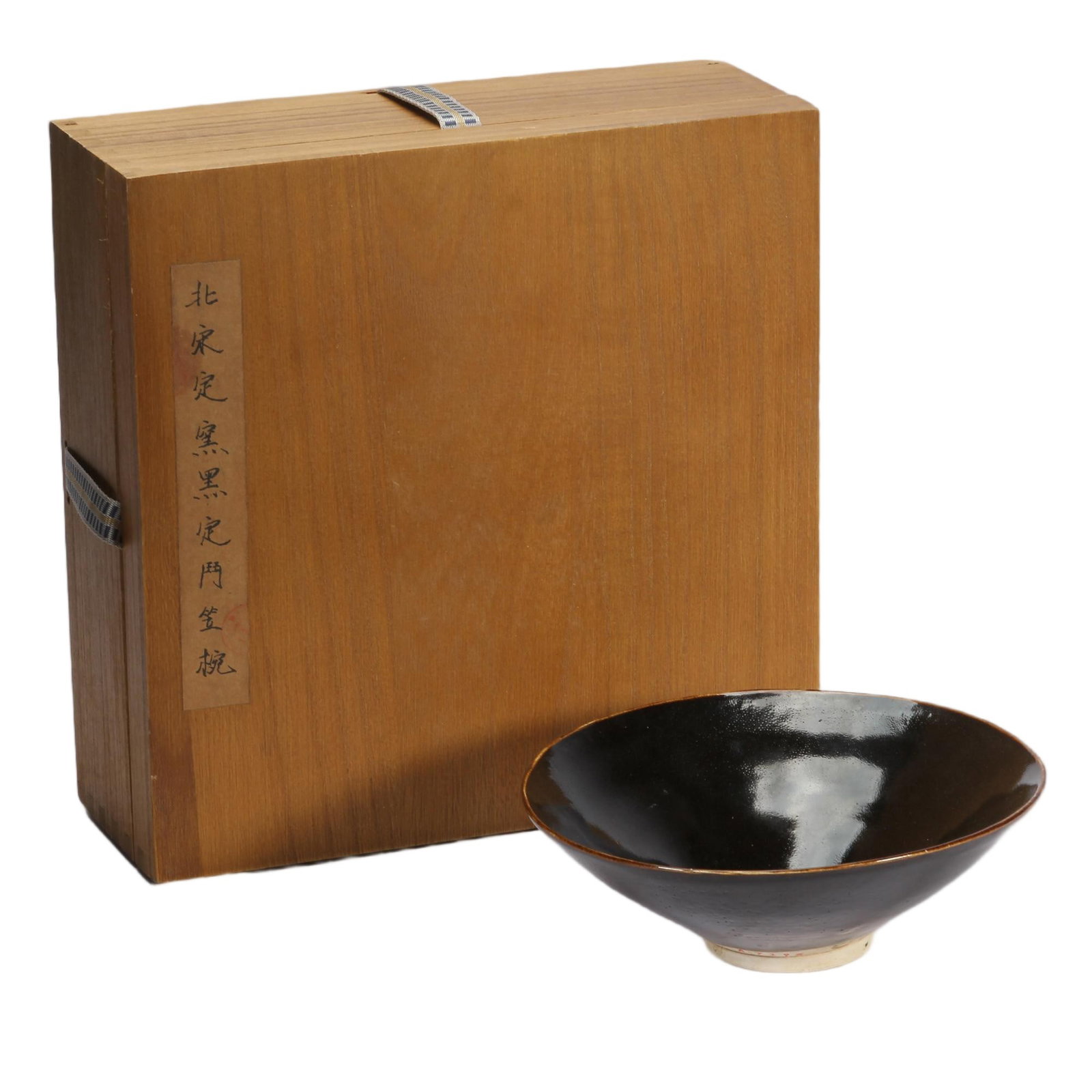 A CHINESE DING-TYPE BLACK GLAZE CONICAL BOWL WITH ORIGINAL BOX: A CHINESE DING-TYPE BLACK GLAZE CONICAL BOWL WITH ORIGINAL BOX This elegant conical tea bowl is fully covered in glossy deep black glaze extending to the thin brown-rimmed mouth edge, revealing pale c