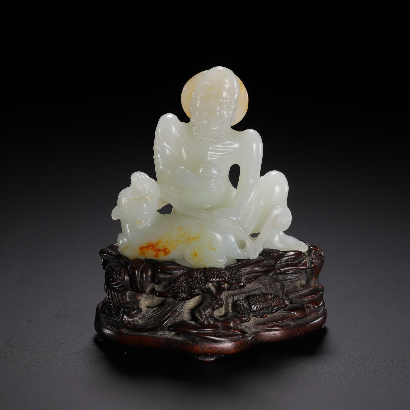 A CHINESE HETIAN WHITE JADE LUOHAN WITH LION CARVING: A CHINESE HETIAN WHITE JADE LUOHAN WITH LION CARVING Carved from fine Hetian white jade with soft milky luster, this sculpture depicts a gaunt luohan seated in relaxed repose beside a recumbent lion. 