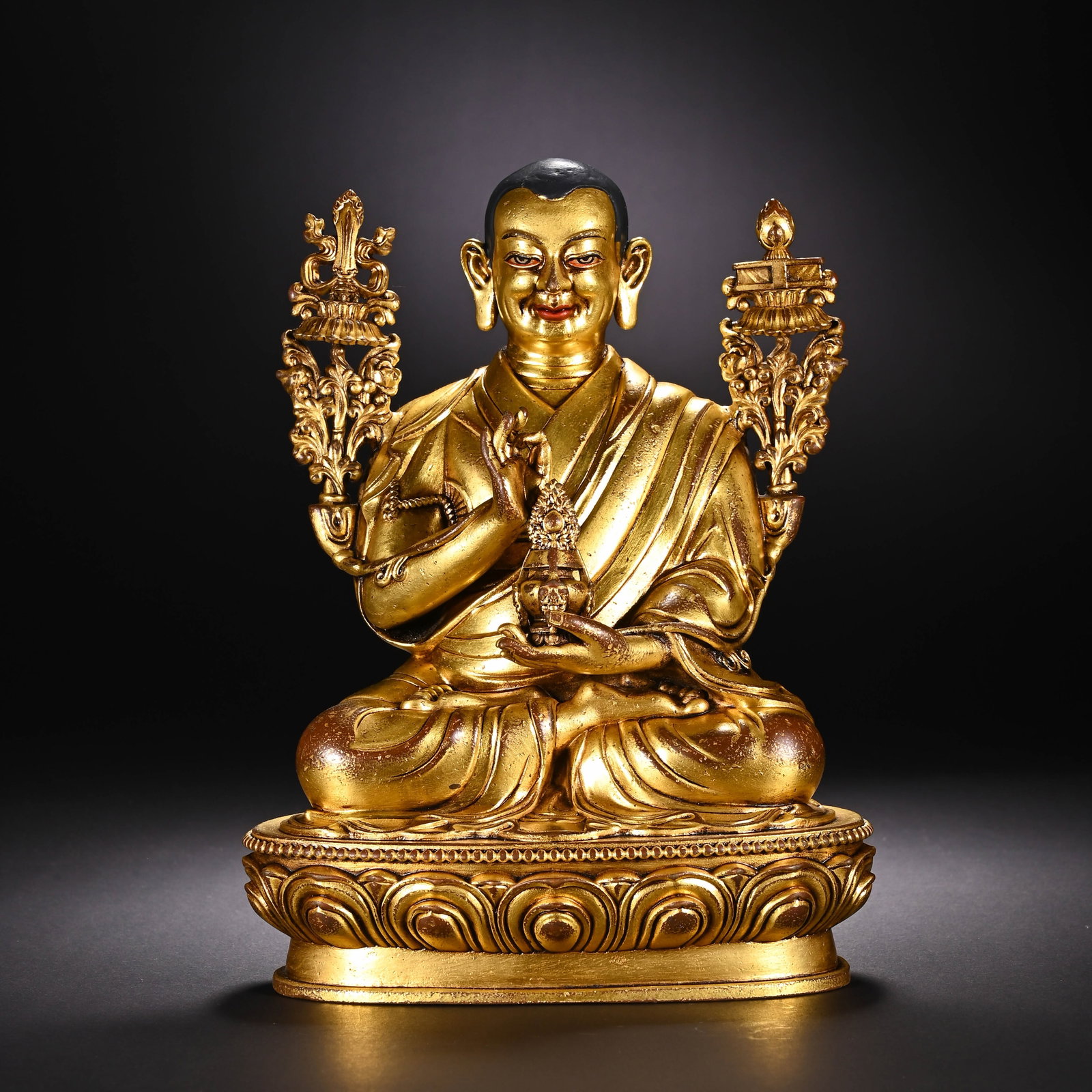 A CHINESE GILT BRONZE TSONGKHAPA LAMA STATUE: A CHINESE GILT BRONZE TSONGKHAPA LAMA STATUE This fully gilt bronze figure depicts Tsongkhapa, founder of the Gelug school of Tibetan Buddhism, seated in full lotus position upon an ornate double lotu