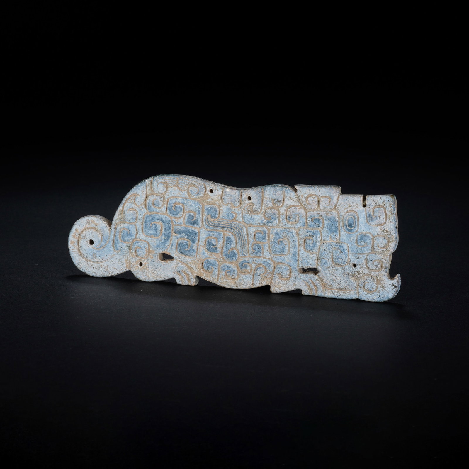 A CHINESE ARCHAIC JADE TIGER PENDANT: A CHINESE ARCHAIC JADE TIGER PENDANT This flat carved jade tiger plaque measures 12.5 cm long, 4 cm wide and 0.6 cm thick, weighing 61 grams. The nephrite body is heavily altered to a mottled pale blu