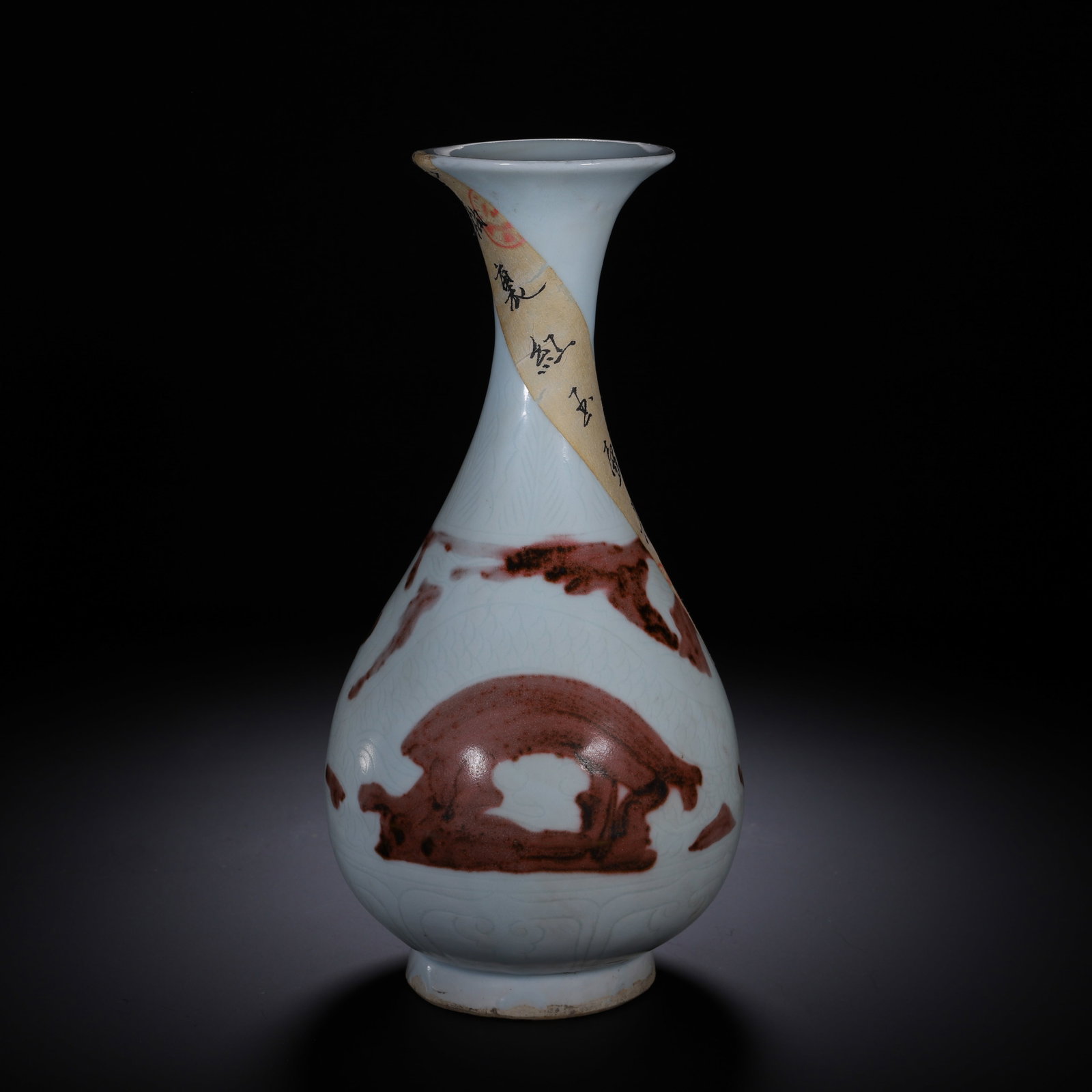A CHINESE UNDERGLAZE RED YUHUCHUN VASE: A CHINESE UNDERGLAZE RED YUHUCHUN VASE This classic pear-shaped Yuhuchun vase features a flared trumpet mouth, slender tapering neck, rounded bulbous body and short circular foot. The vessel is coated