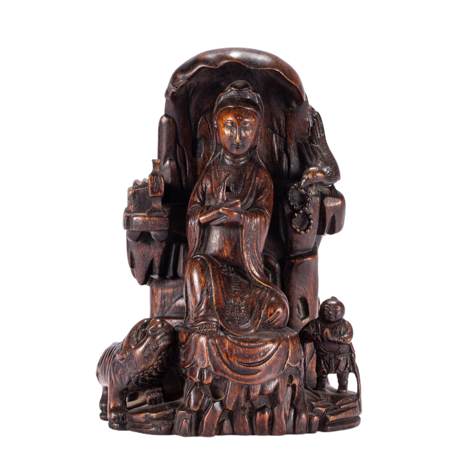 A CHINESE AGARWOOD CARVED GUANYIN MOUNTAIN GROUP: A CHINESE AGARWOOD CARVED GUANYIN MOUNTAIN GROUP This elaborate figural group is fully carved from solid agarwood with rich dark honey-brown patina and natural aromatic grain. Seated within a hollowed