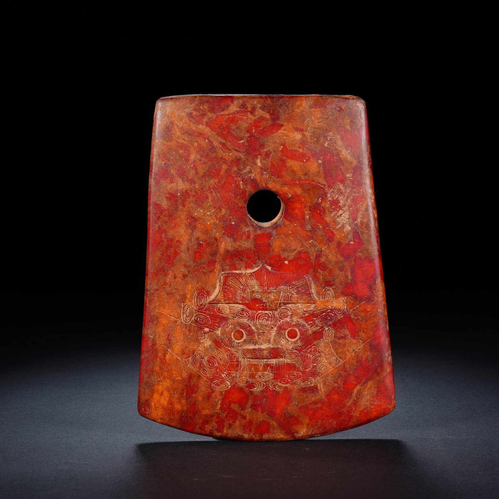 A CHINESE ARCHAIC JADE AXE BLADE: A CHINESE ARCHAIC JADE AXE BLADE This ceremonial jade axe blade measures 13.5cm ? 10.4cm ? 1.4cm and weighs 327 grams. Trapezoidal in outline, it features a smoothly polished rounded cutting edge and 