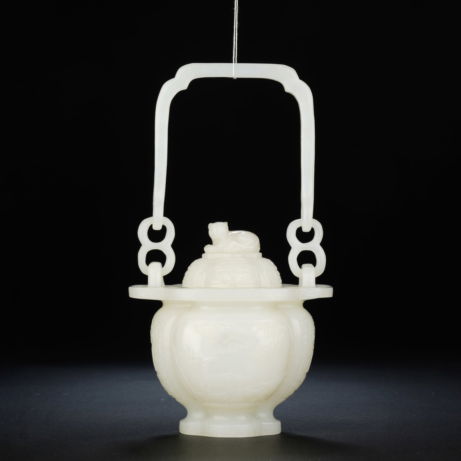 A CHINESE WHITE JADE CENSER WITH MYTHICAL BEAST FINIAL & SUSPENDED HANDLE: A CHINESE WHITE JADE CENSER WITH MYTHICAL BEAST FINIAL & SUSPENDED HANDLE This exquisite nephrite jade censer measures 9cm ? 5.5cm ? 17cm and weighs 272 grams. The lobed bulbous body rises on a compac